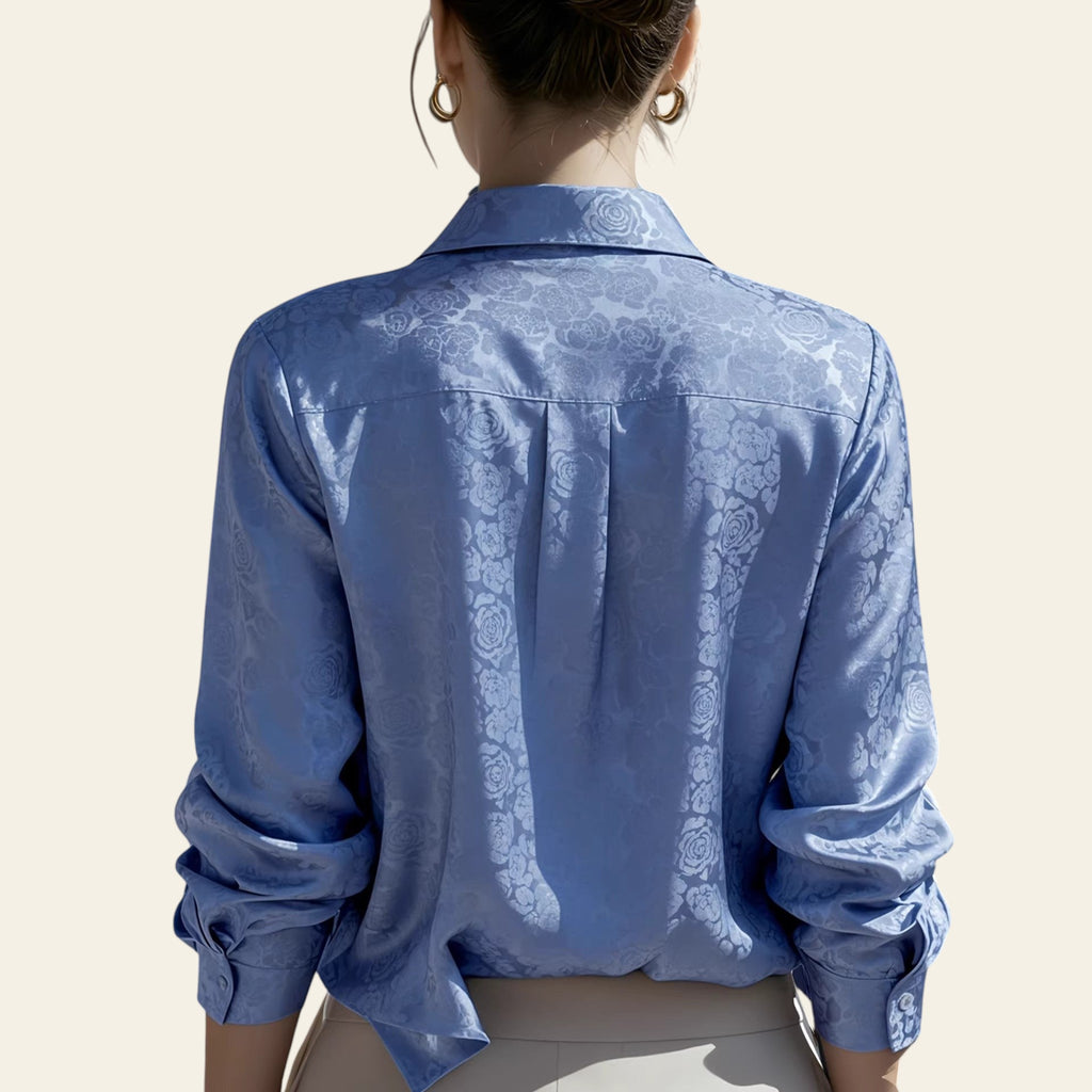 Person wearing a blue patterned shirt with a blurred background