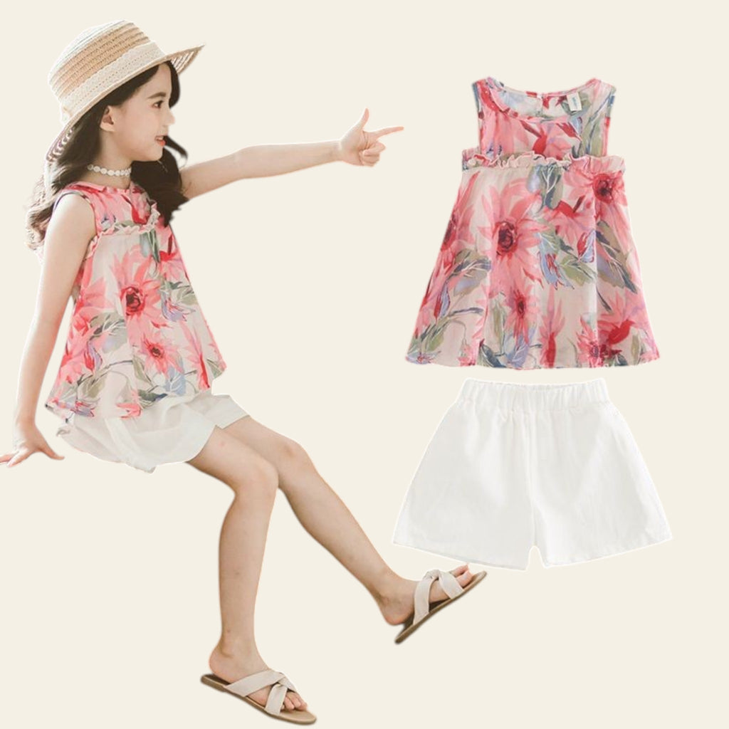 Young girl pointing at a floral top and white shorts on a dark background