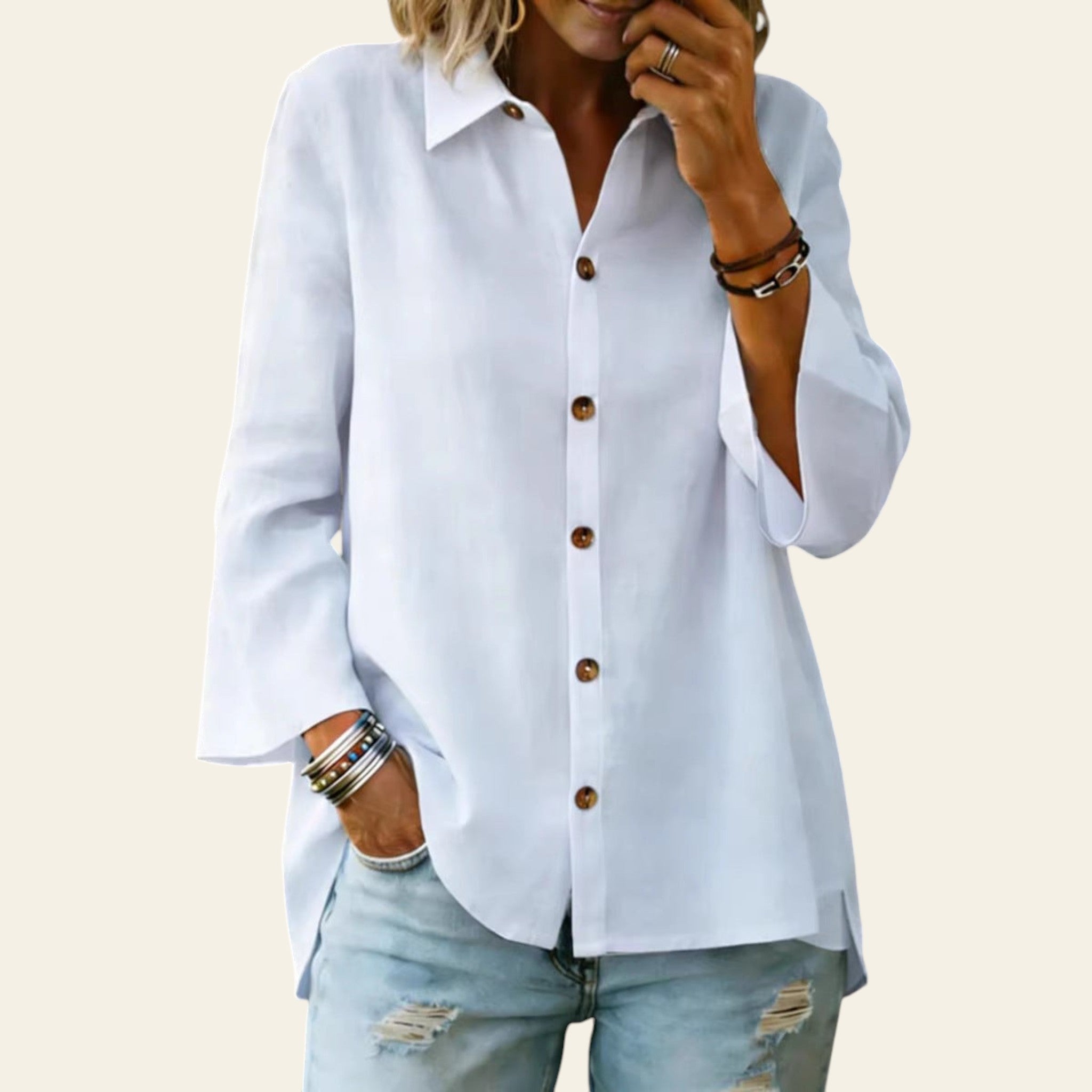 Person wearing a white button-up shirt and light blue jeans with a blurred background
