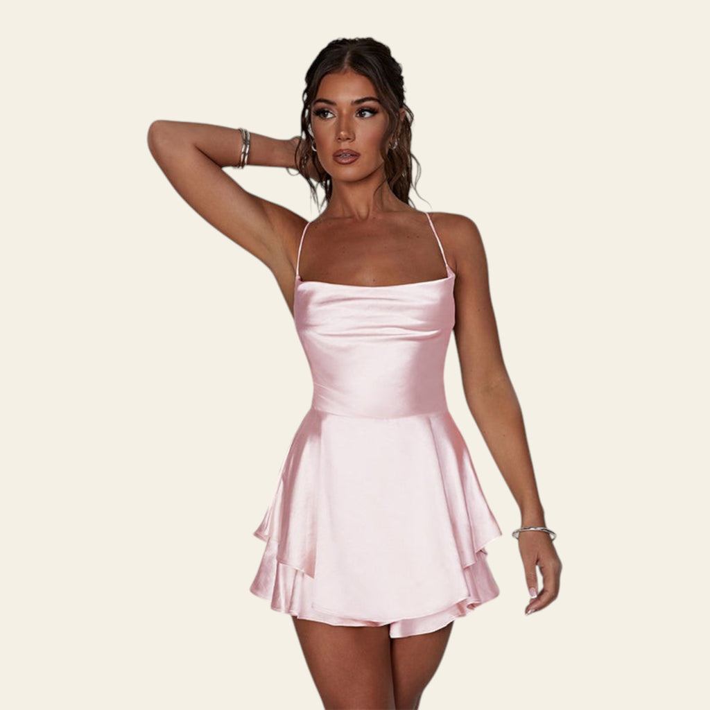 Woman wearing a pink satin dress against a plain background