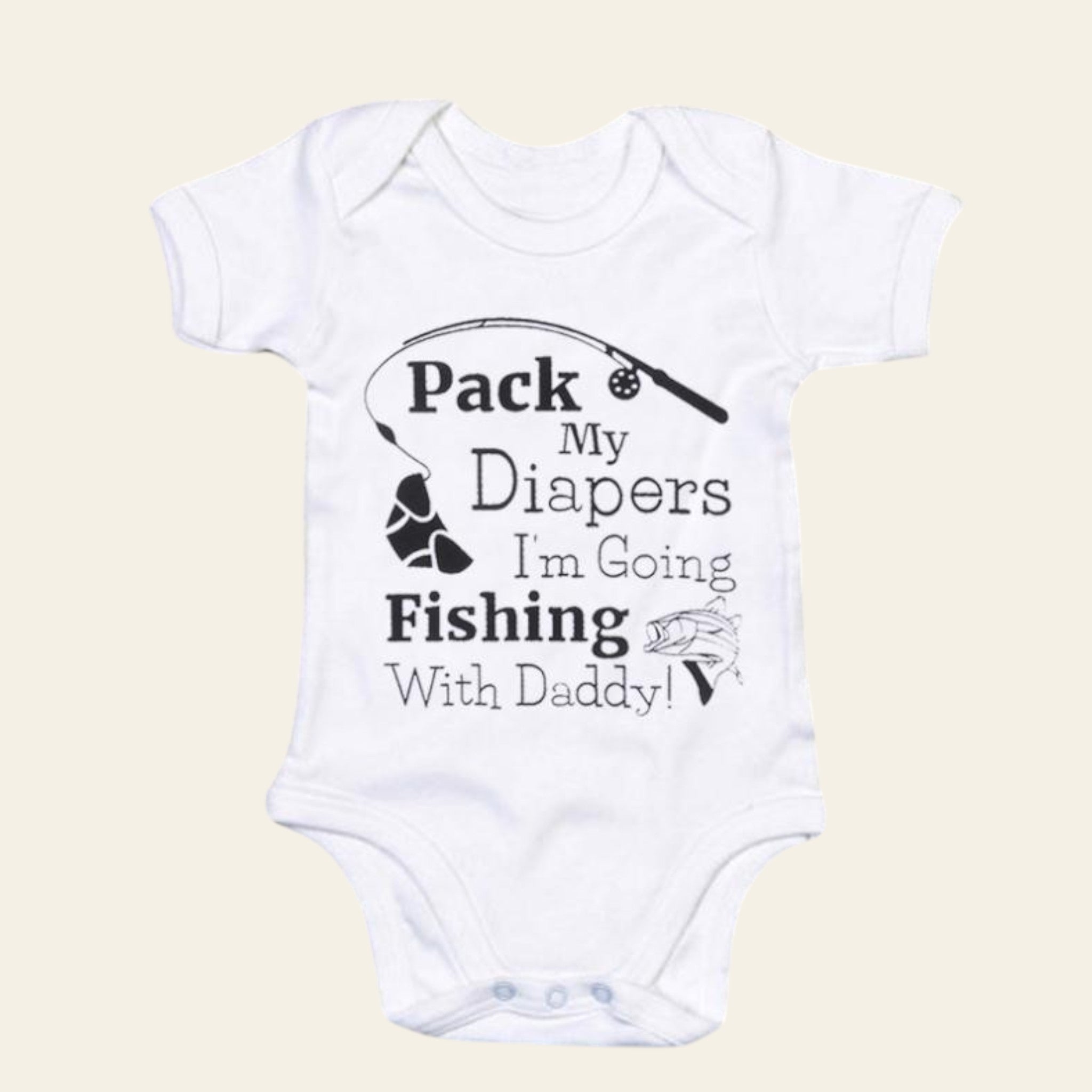 White baby onesie with text 'Pack My Diapers I'm Going Fishing With Daddy!' on a beige background