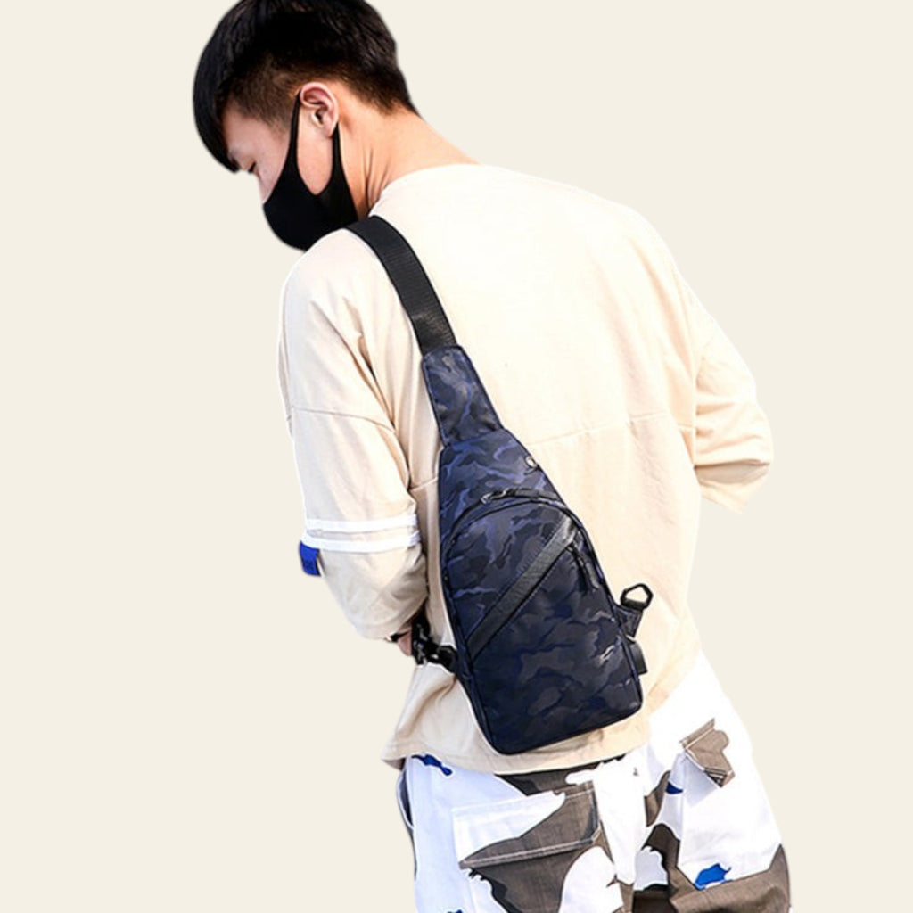 Person wearing a navy sling bag in an urban setting