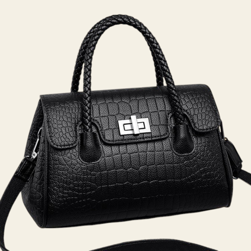 Black textured handbag with braided handle on a beige background