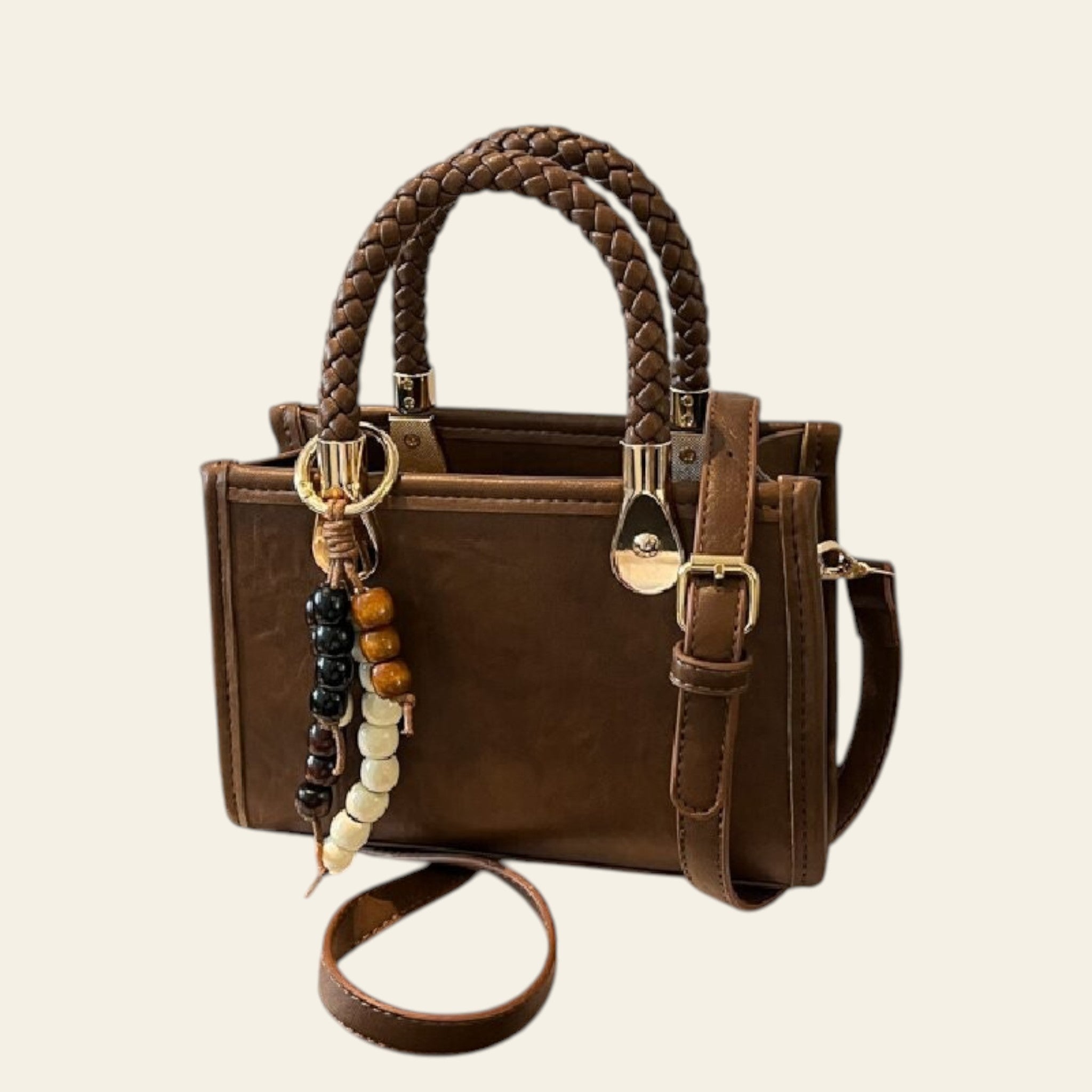Brown handbag with braided handle and keychain on a white box with 'Tom Ford' branding.