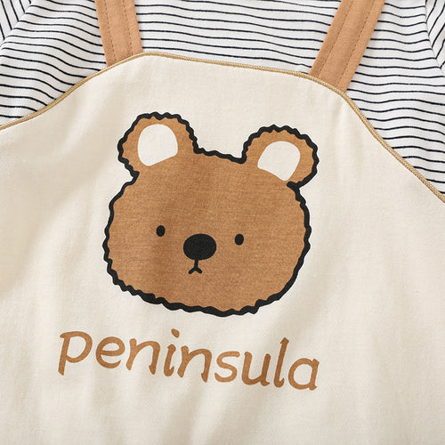 Beige apron with bear design and 'peninsula' text, worn over a striped shirt.