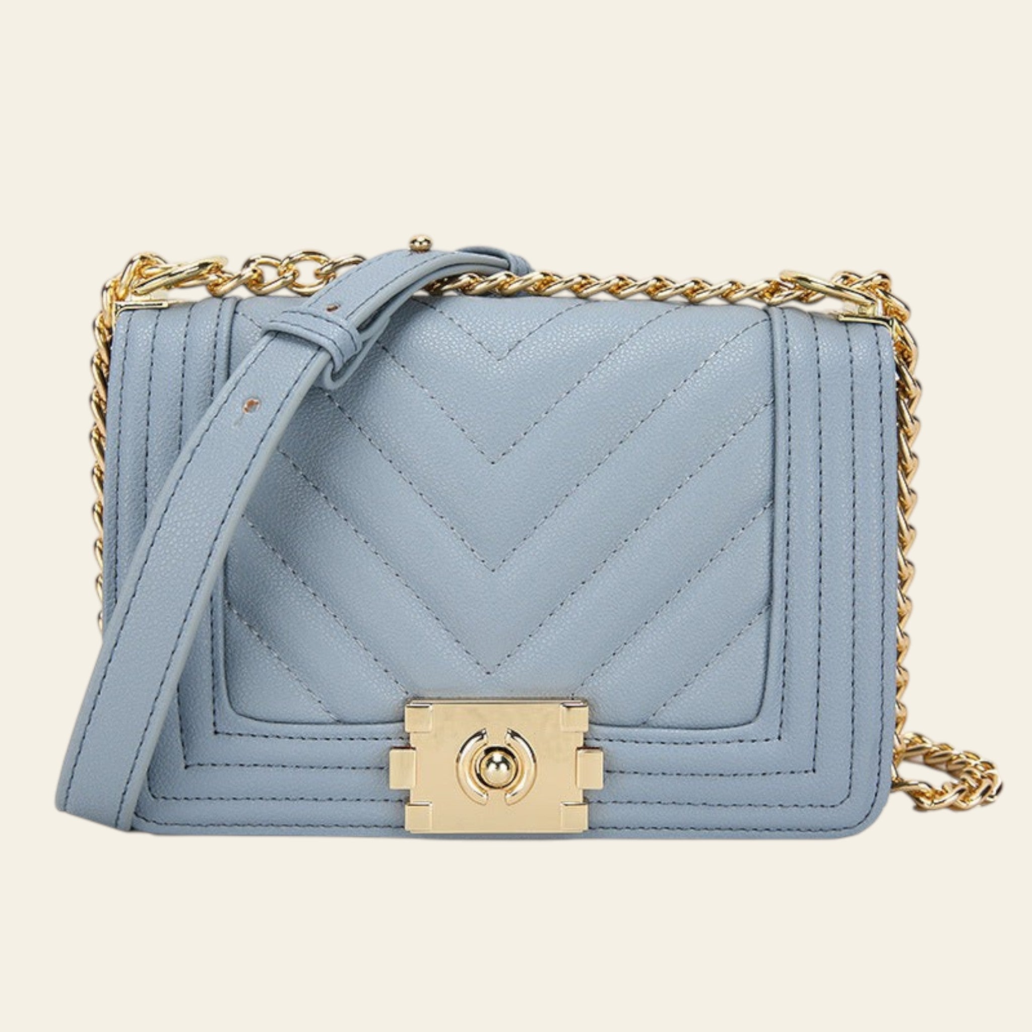 Light blue handbag with gold chain and clasp on a white background