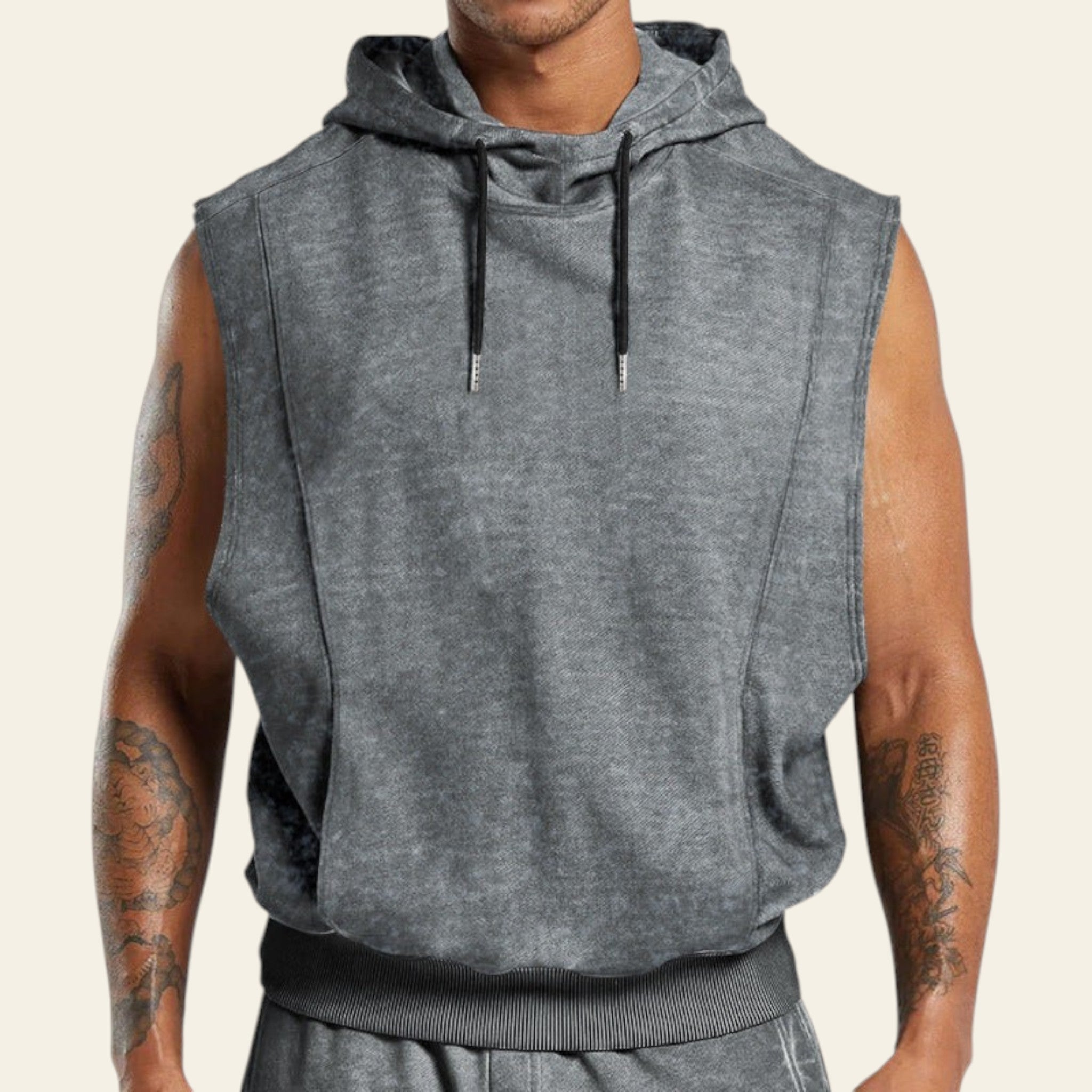 Man wearing a gray sleeveless hoodie on a white background