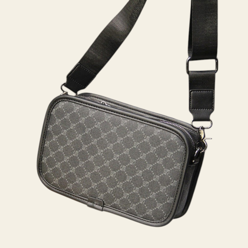 Gray checkered crossbody bag on a wooden table with a blurred background