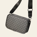 Gray checkered crossbody bag on a wooden table with a blurred background