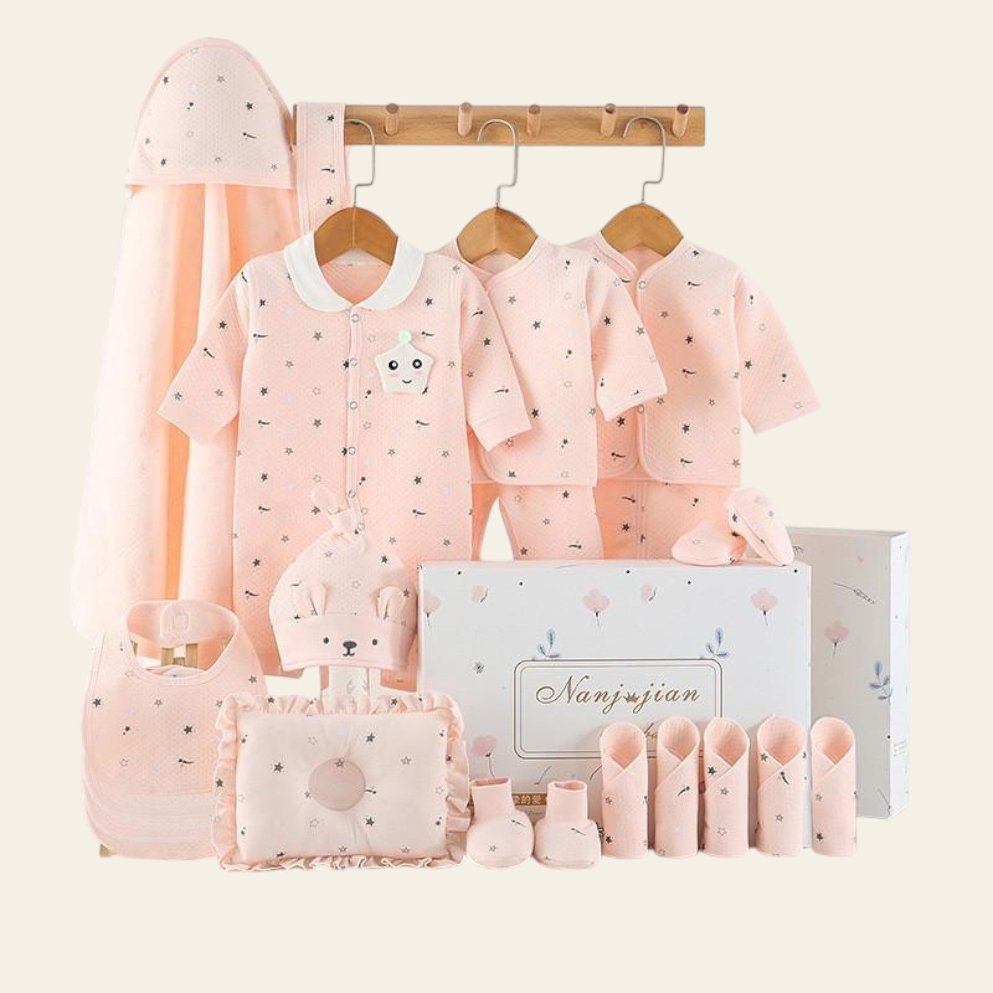 Baby clothing set with pink outfits, accessories, and a box on a white background