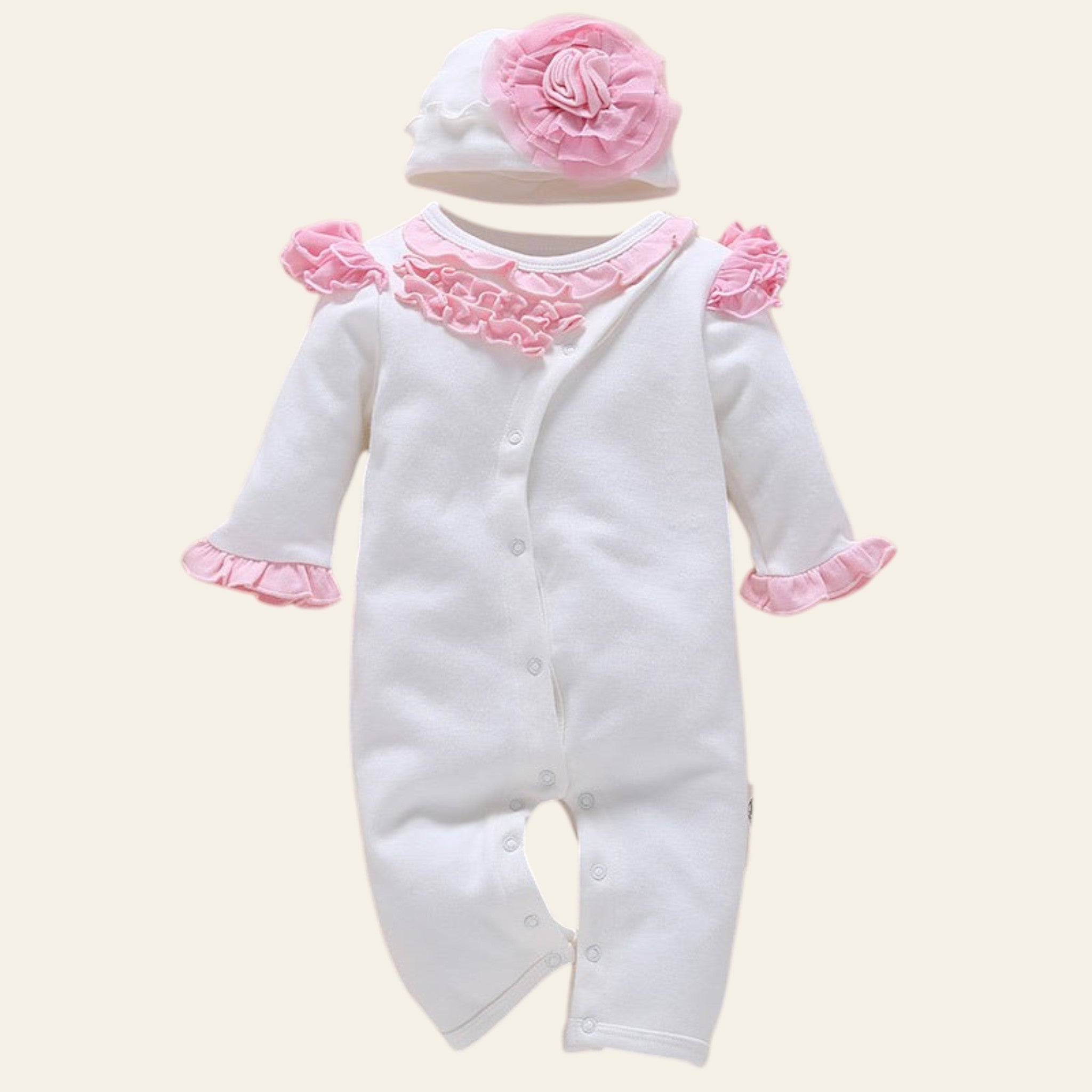 White baby romper with pink trim and matching hat on a beige background