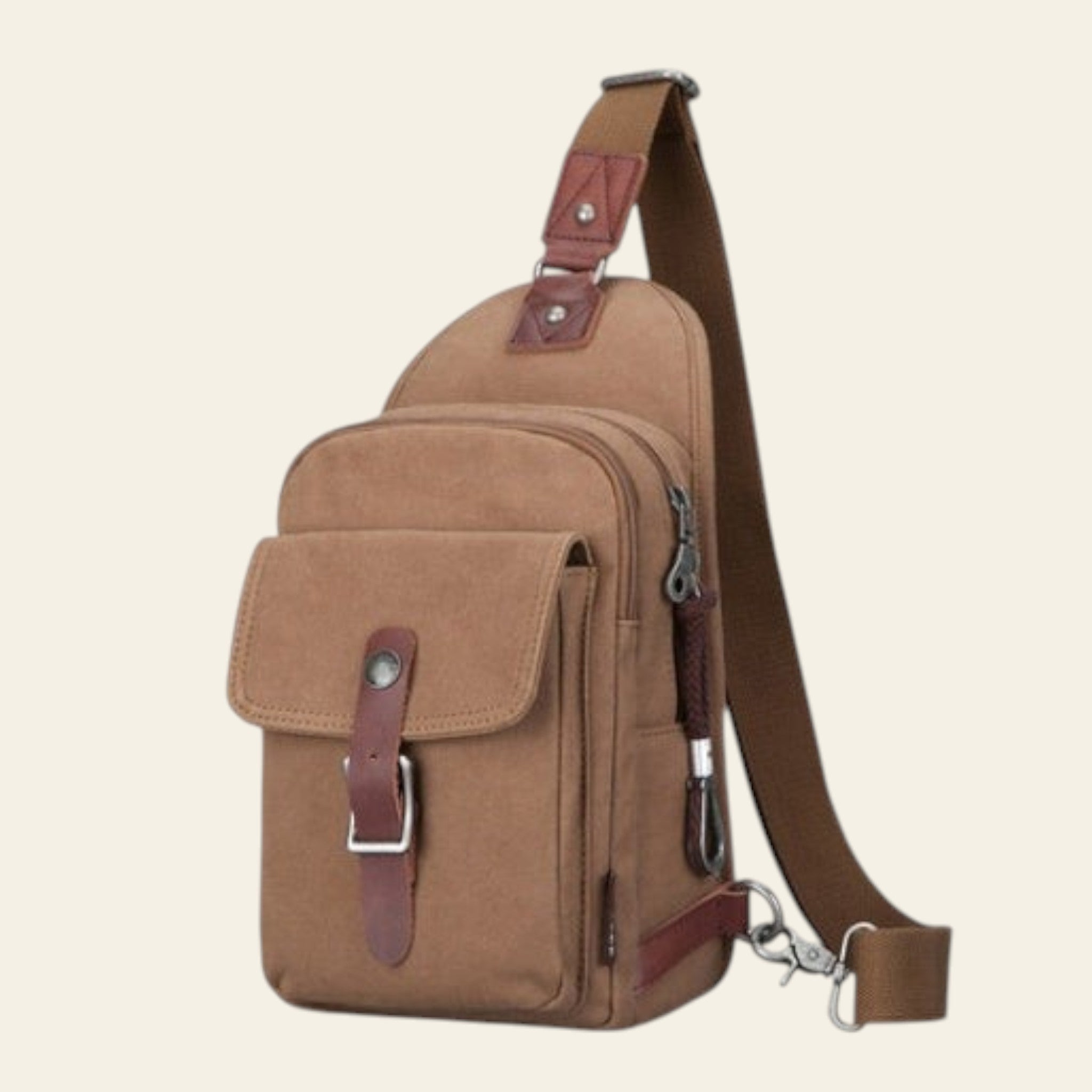 Brown canvas sling bag with leather accents on a white background