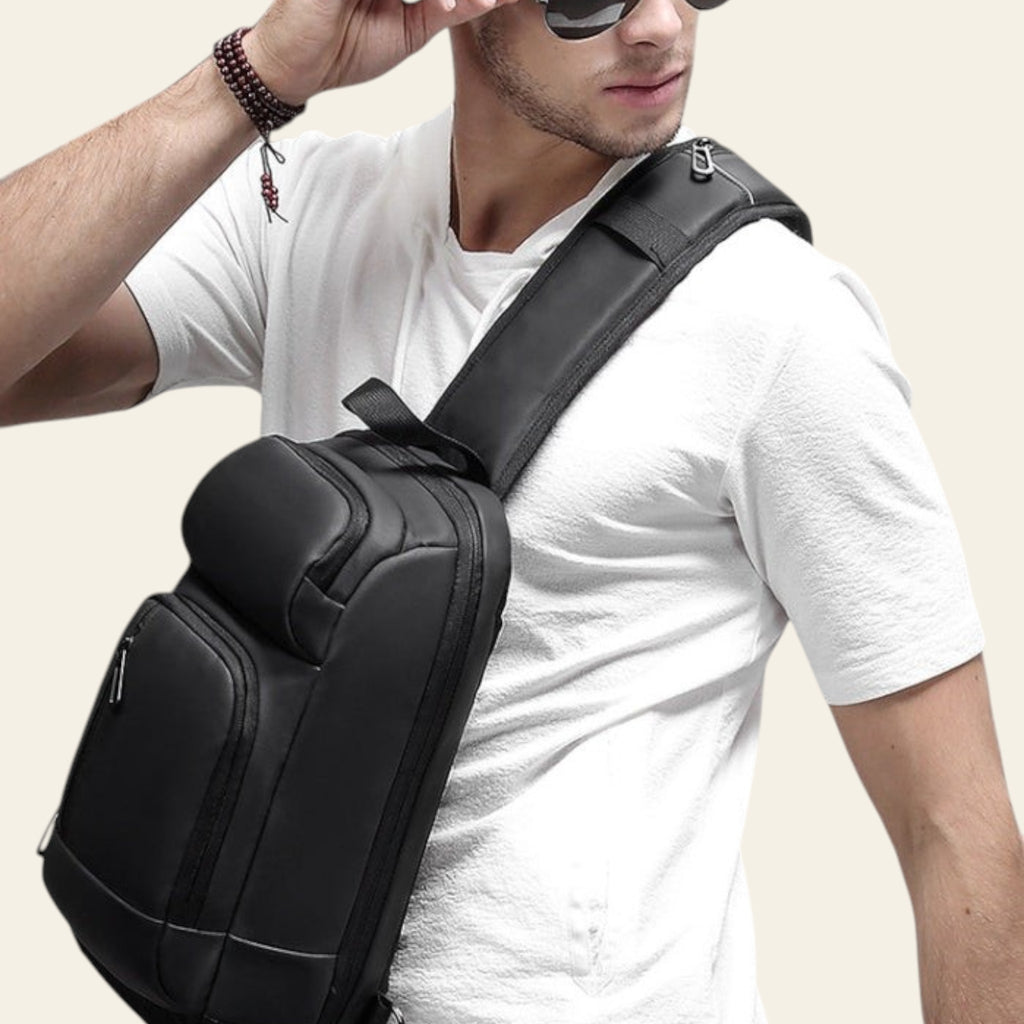 Man wearing a black shoulder bag on a gray background