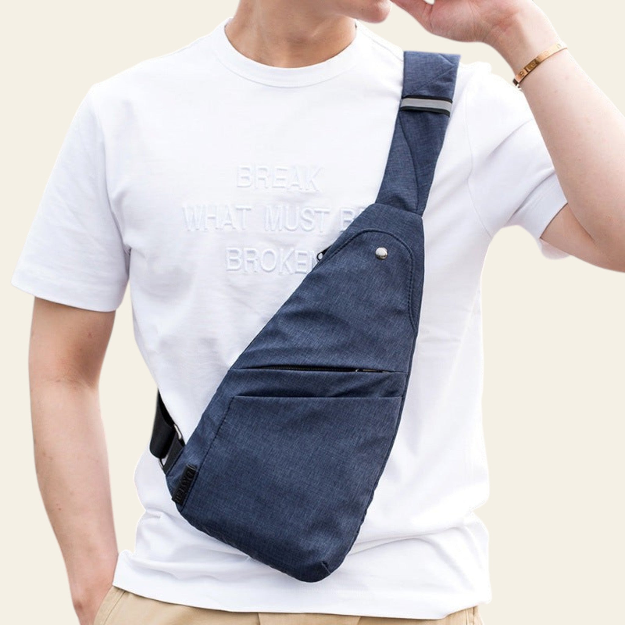 Person wearing a navy blue crossbody bag over one shoulder outdoors.