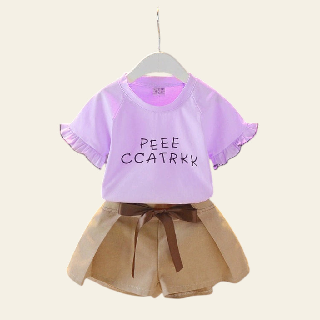 Children's outfit with a purple shirt and beige shorts on a hanger against a gray background.