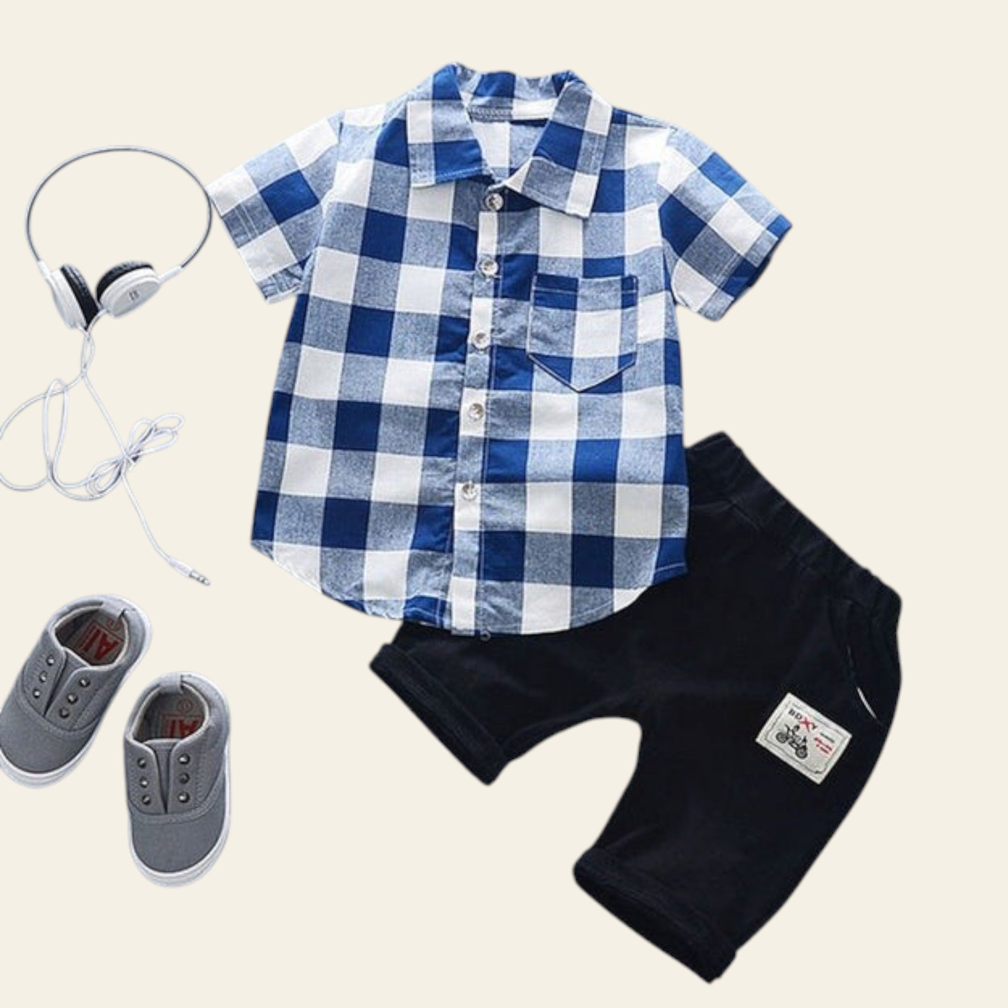 Children's blue and white checkered shirt with black shorts, gray shoes, and headphones on a light blue background.