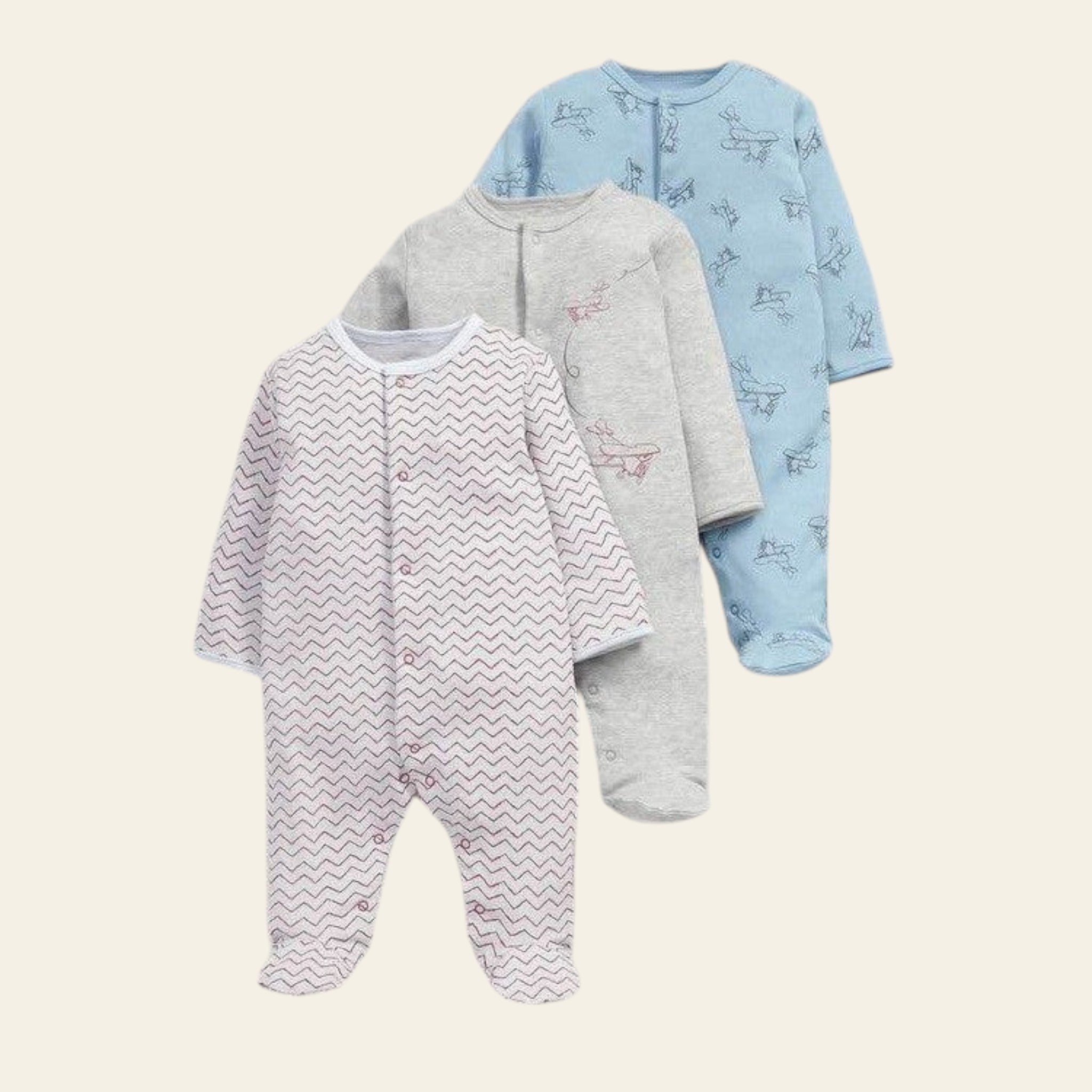 Three baby onesies in different patterns on a light gray background
