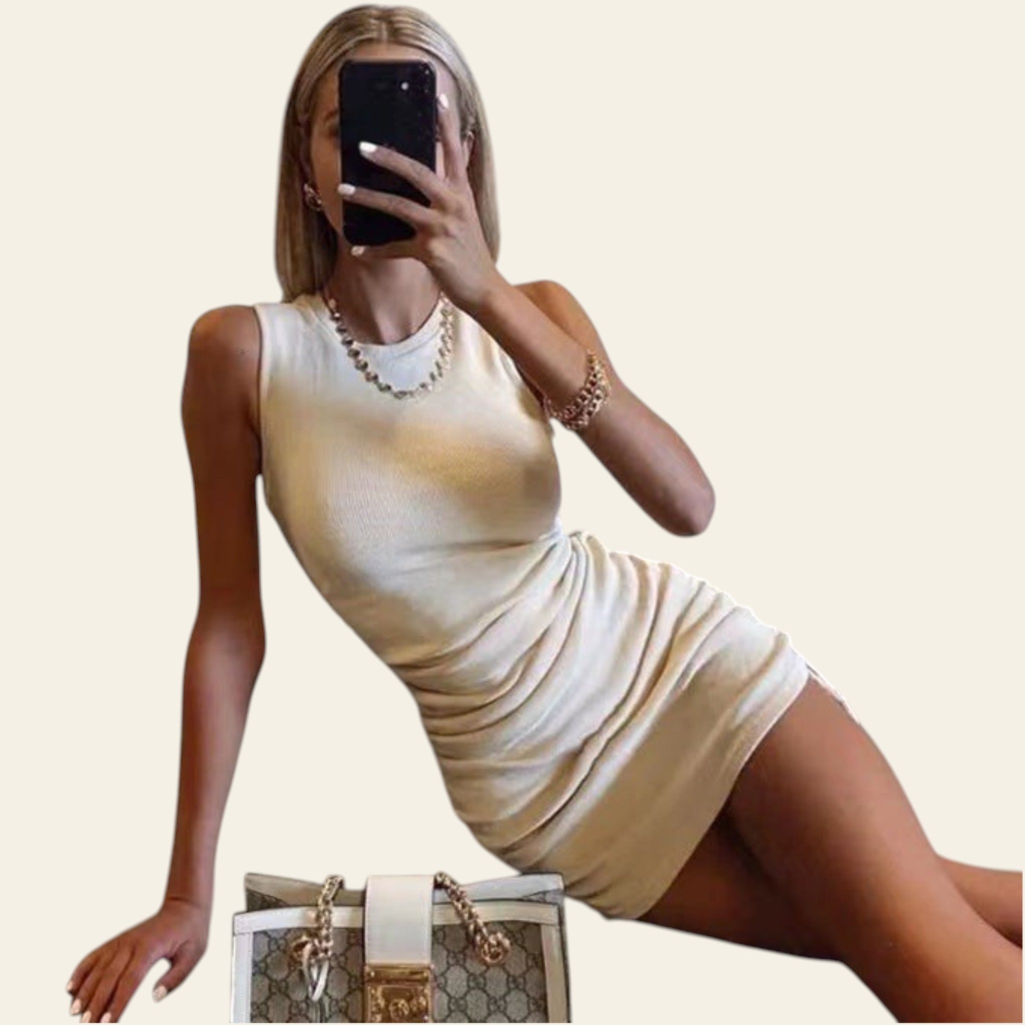 Woman taking a mirror selfie wearing a beige/cream bodycon mini dress