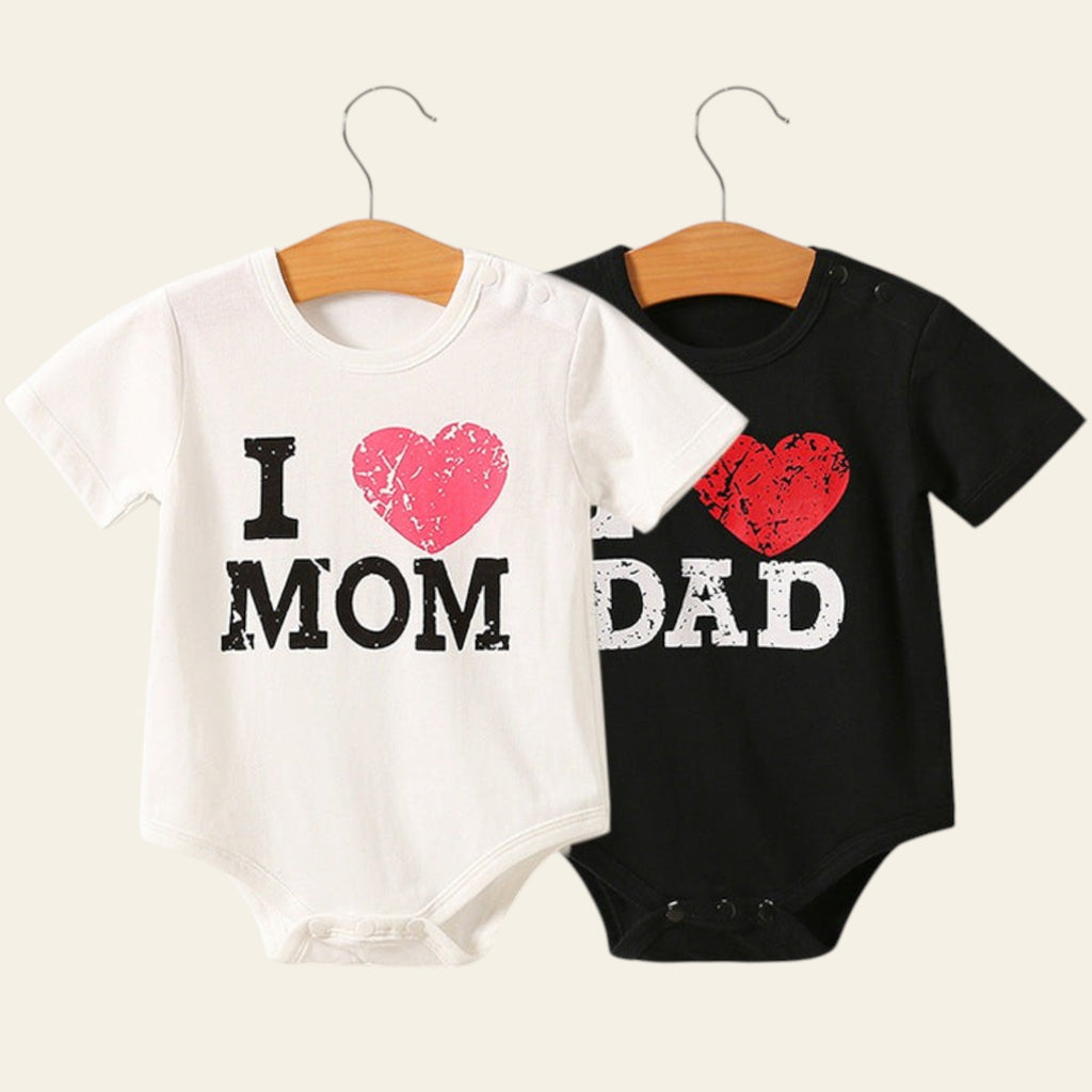 Two baby onesies on hangers with 'I ❤️ MOM' and 'DAD' text.