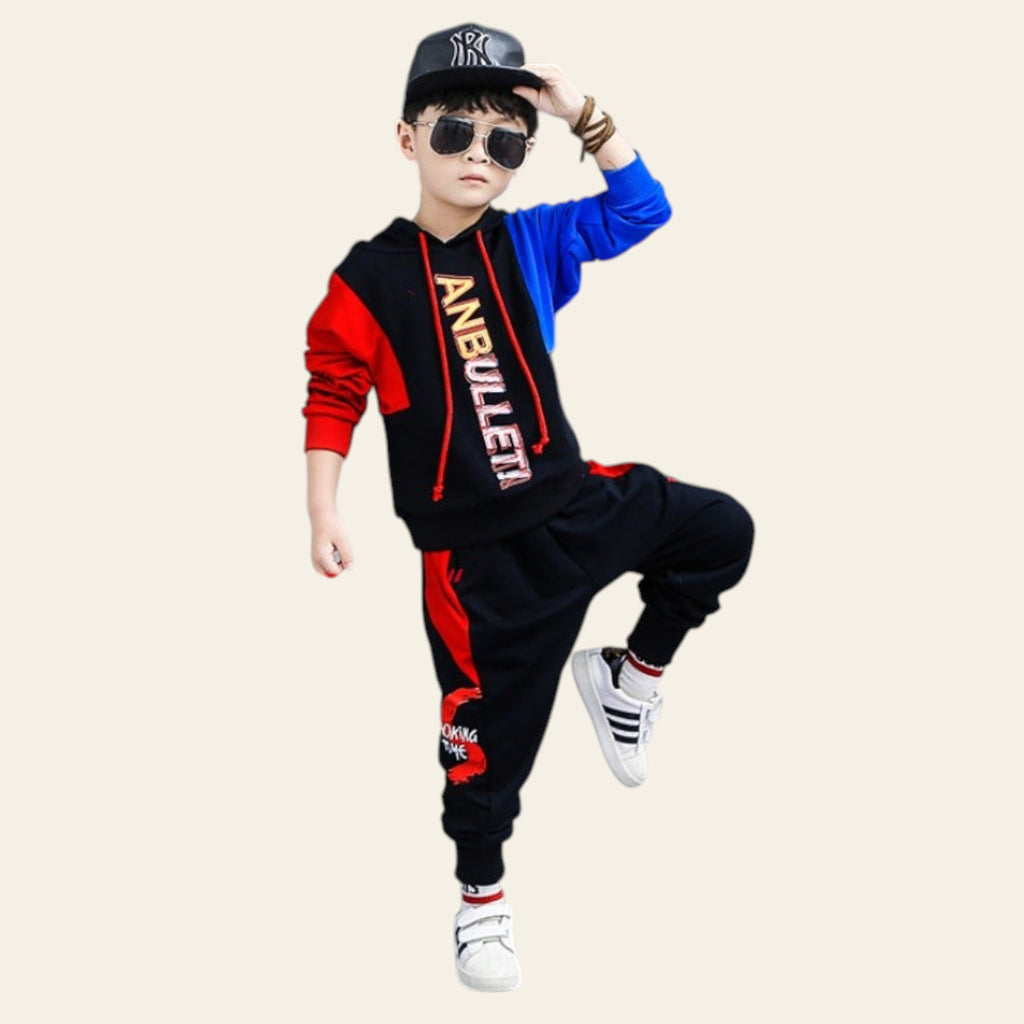 Child wearing a colorful outfit with a brand logo, posing in front of a '#FashionTrend' backdrop.