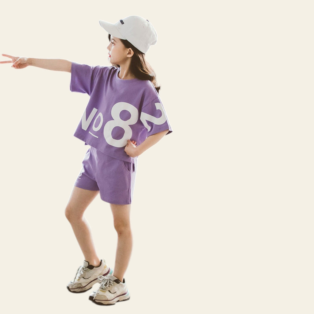 Child wearing a purple outfit with 'NO8' design, standing on a textured surface.