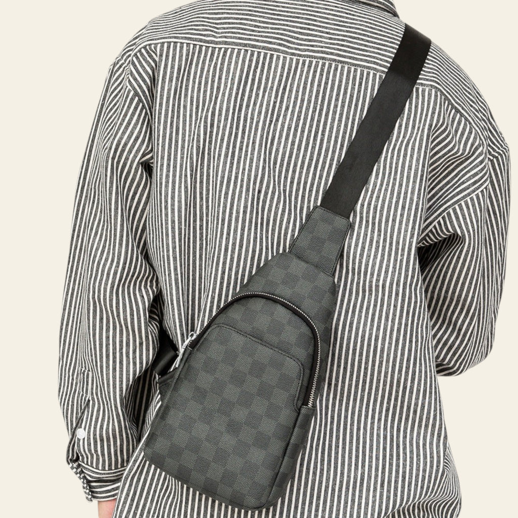 Person wearing a gray checkered crossbody bag on a plain background
