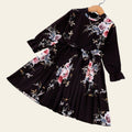 Black dress with floral pattern on a white surface