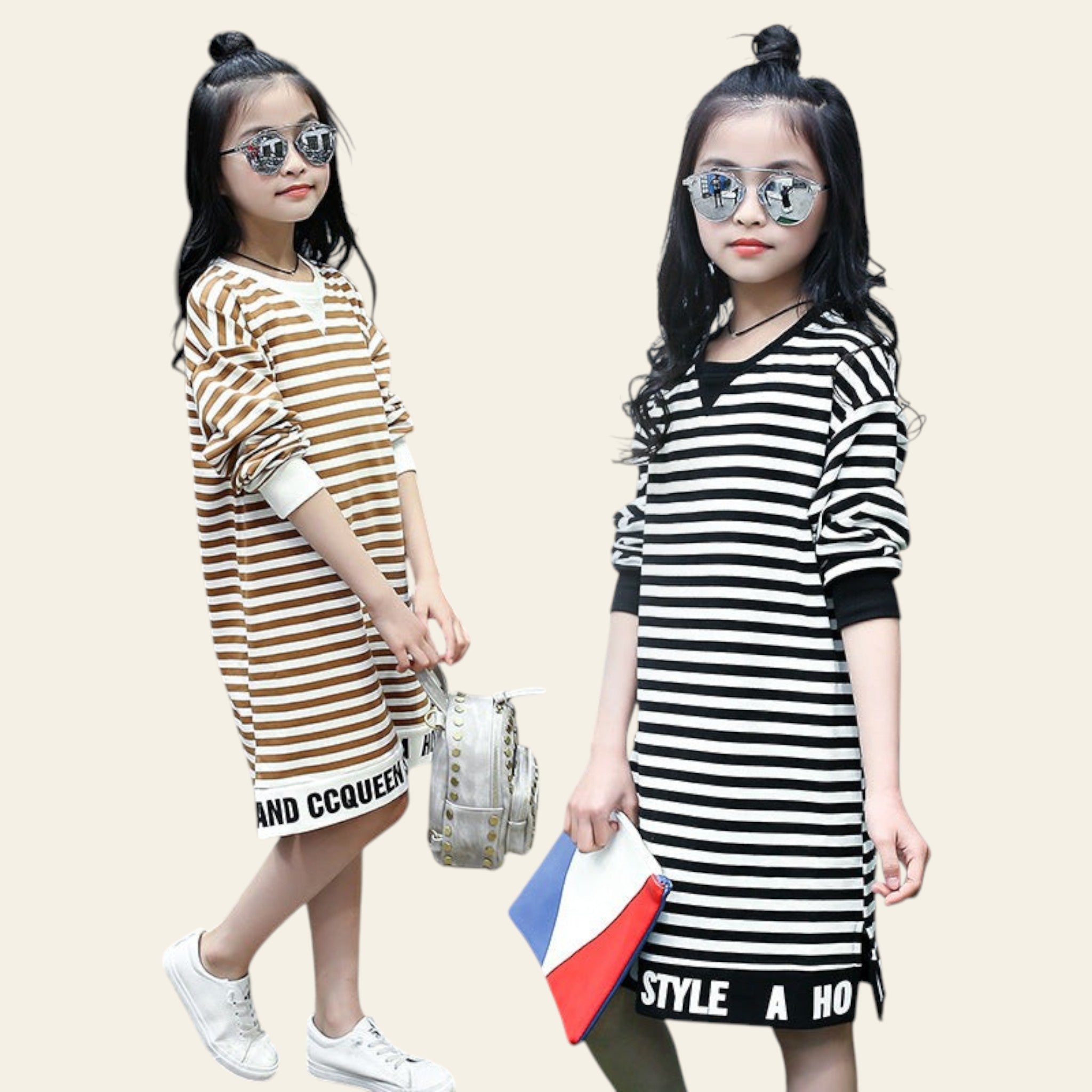 Two young girls wearing striped dresses standing outdoors.