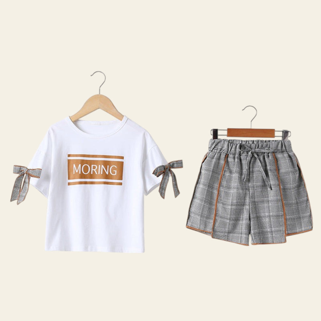 White t-shirt with 'MORING' text and plaid shorts on hangers against a white background