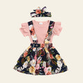 Children's floral dress with pink top and headband on a wooden surface