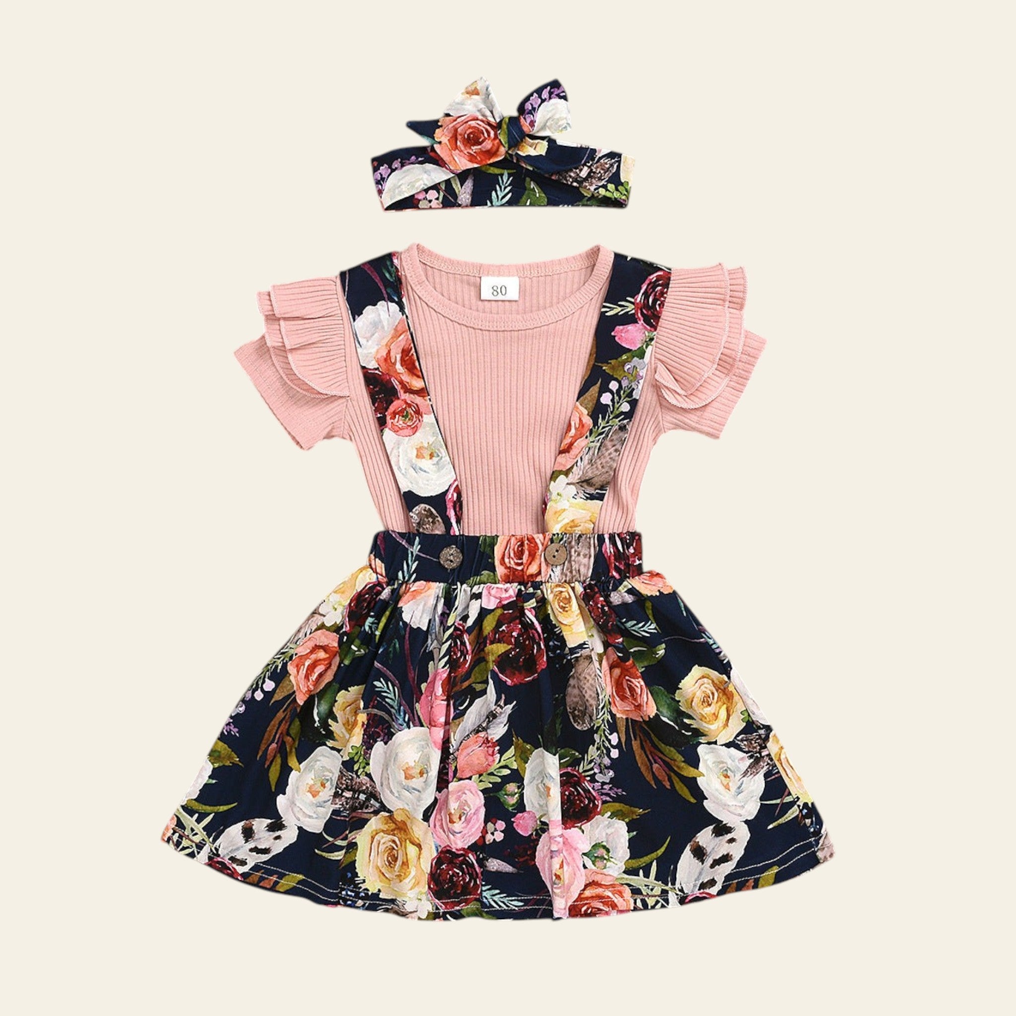Children's floral dress with pink top and headband on a wooden surface