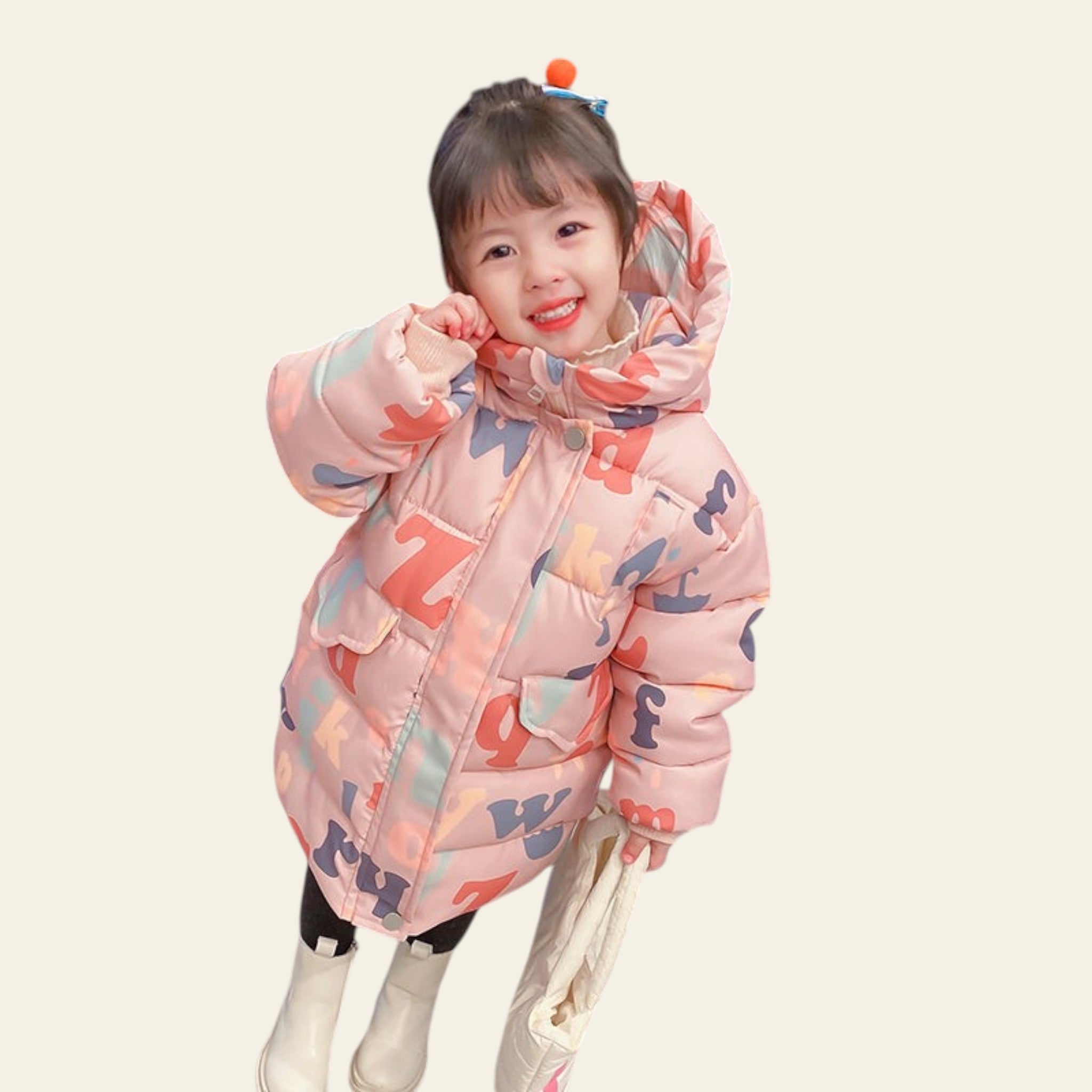 Child wearing a colorful puffer jacket with letter patterns on a marble floor.