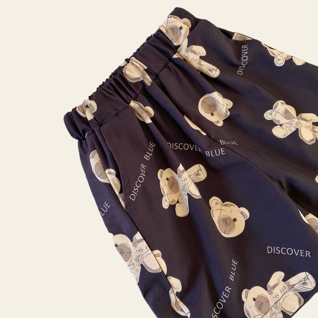 Navy blue fabric with teddy bear pattern next to a magazine titled 'DRIFT' on a beige surface.