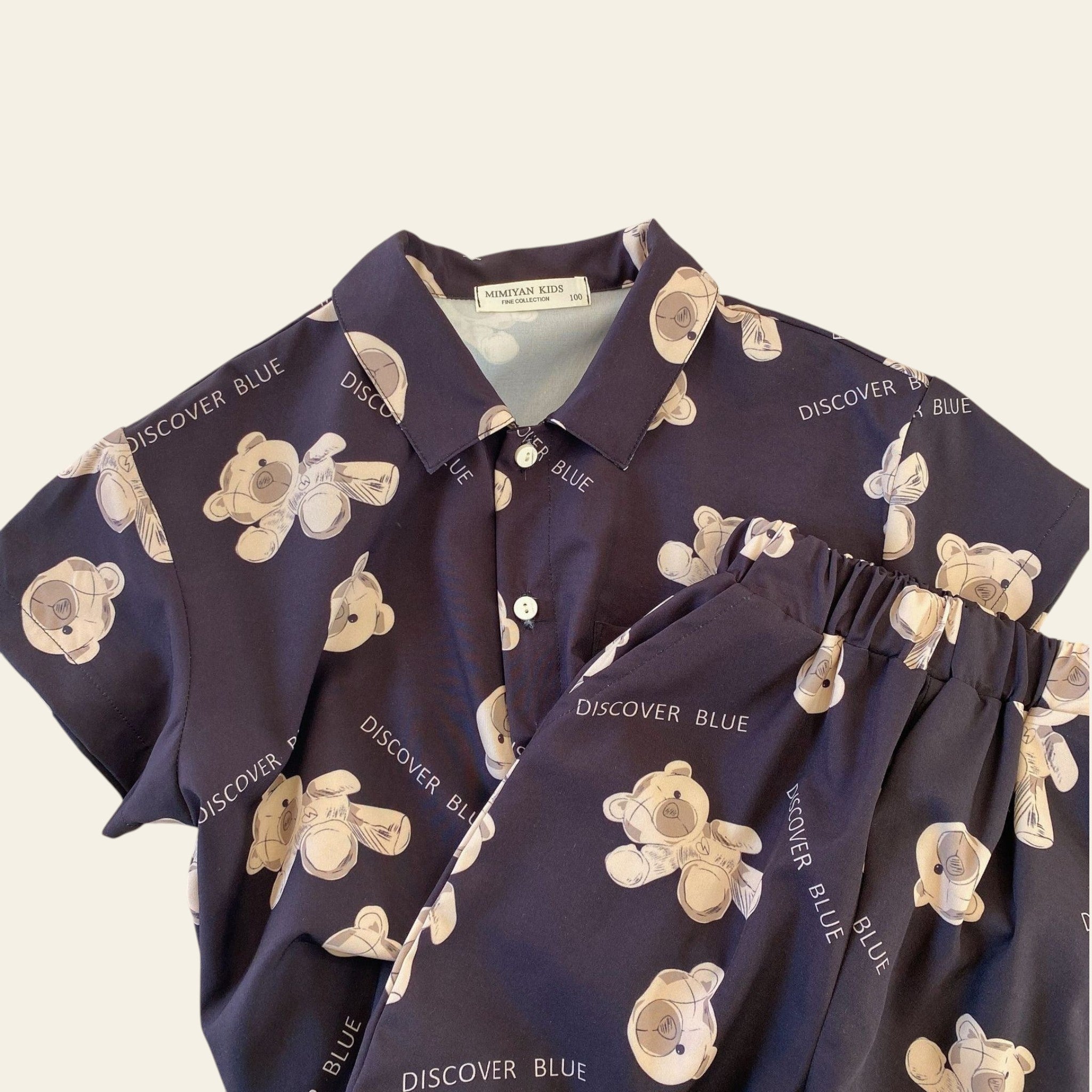 Navy blue shirt with teddy bear pattern on a beige surface