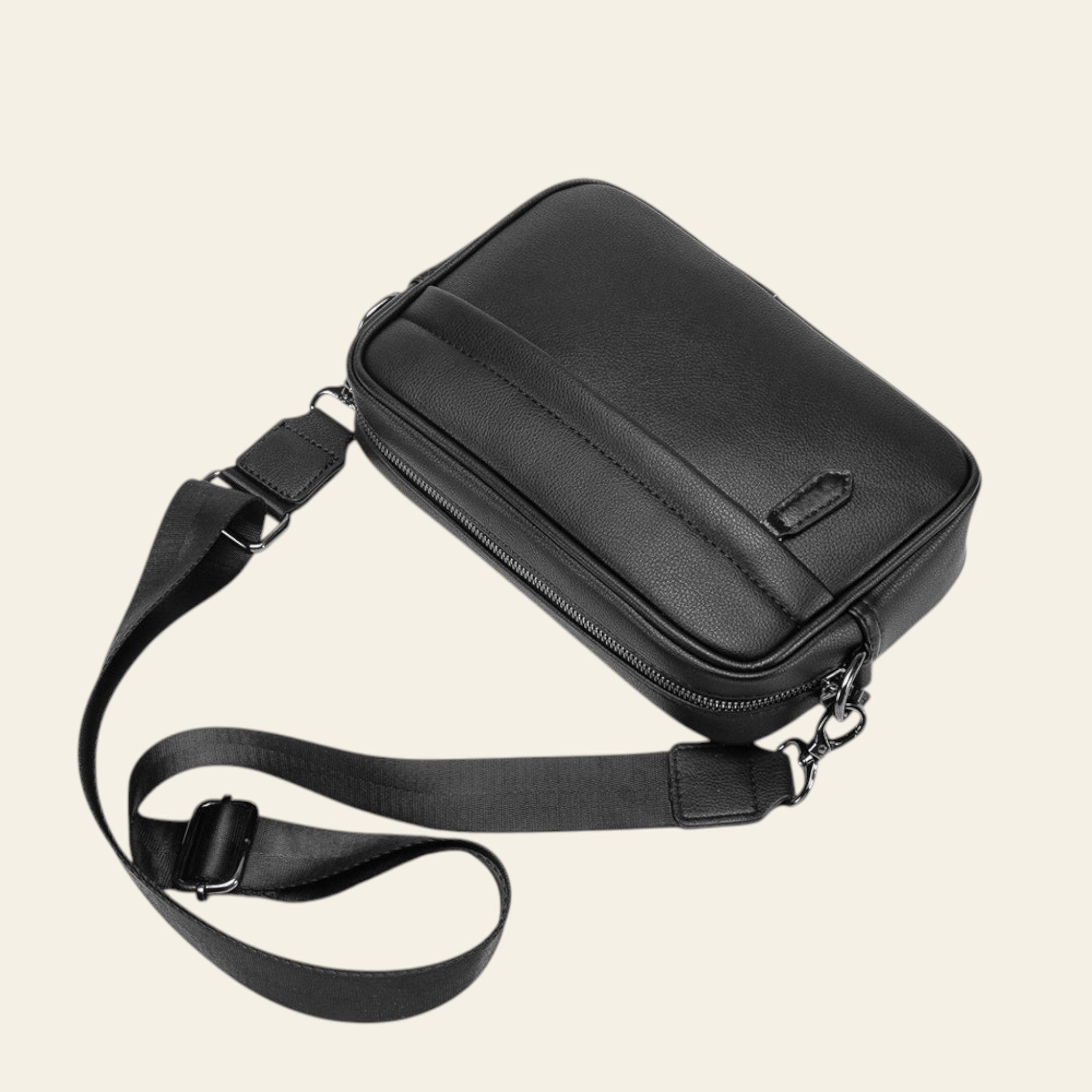 Black shoulder bag with a strap on a white background