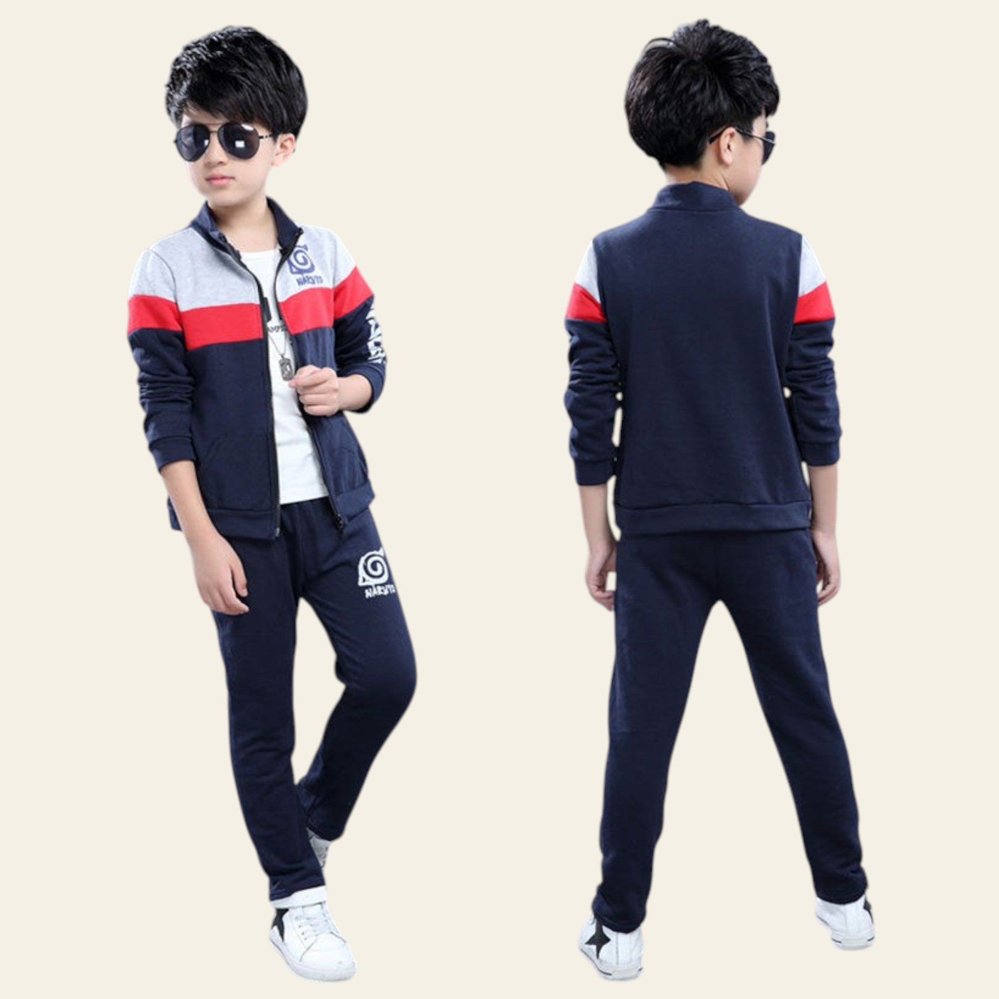 Child wearing a navy tracksuit with red and white accents, standing against a gray background.