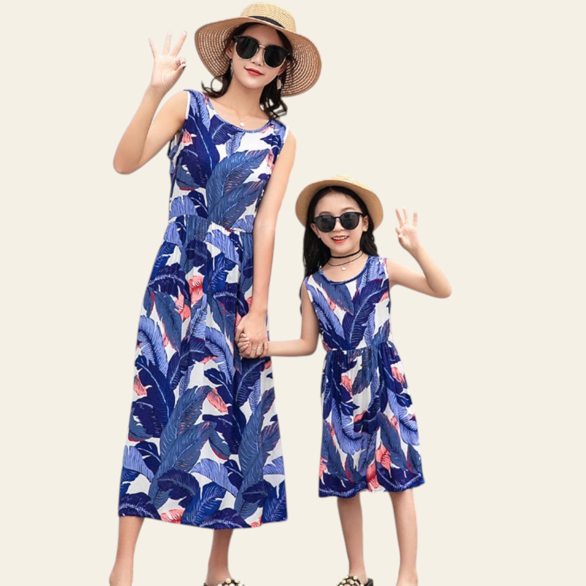 Two women in matching blue floral dresses standing by a poolside.