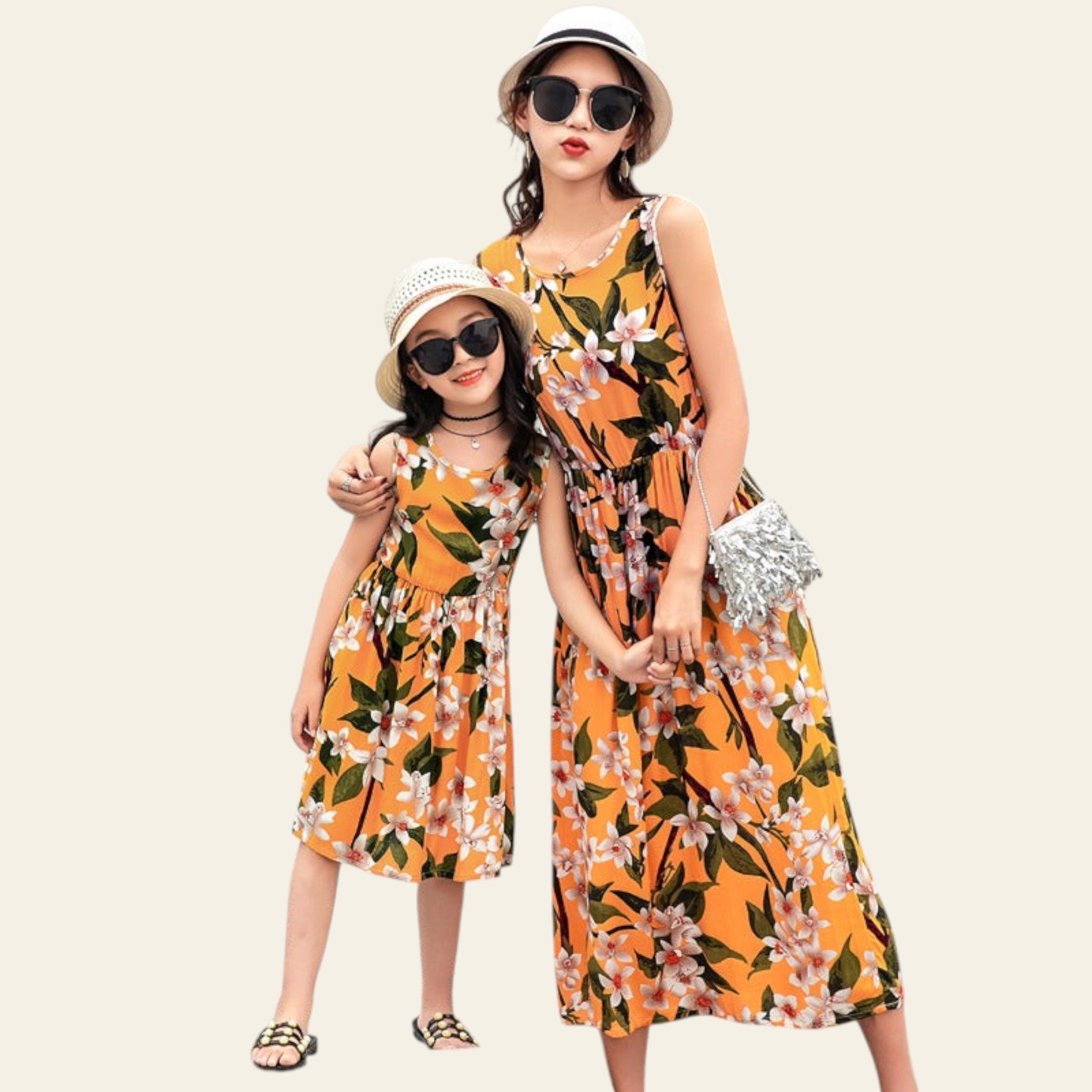 Two women in matching floral dresses standing by a poolside.