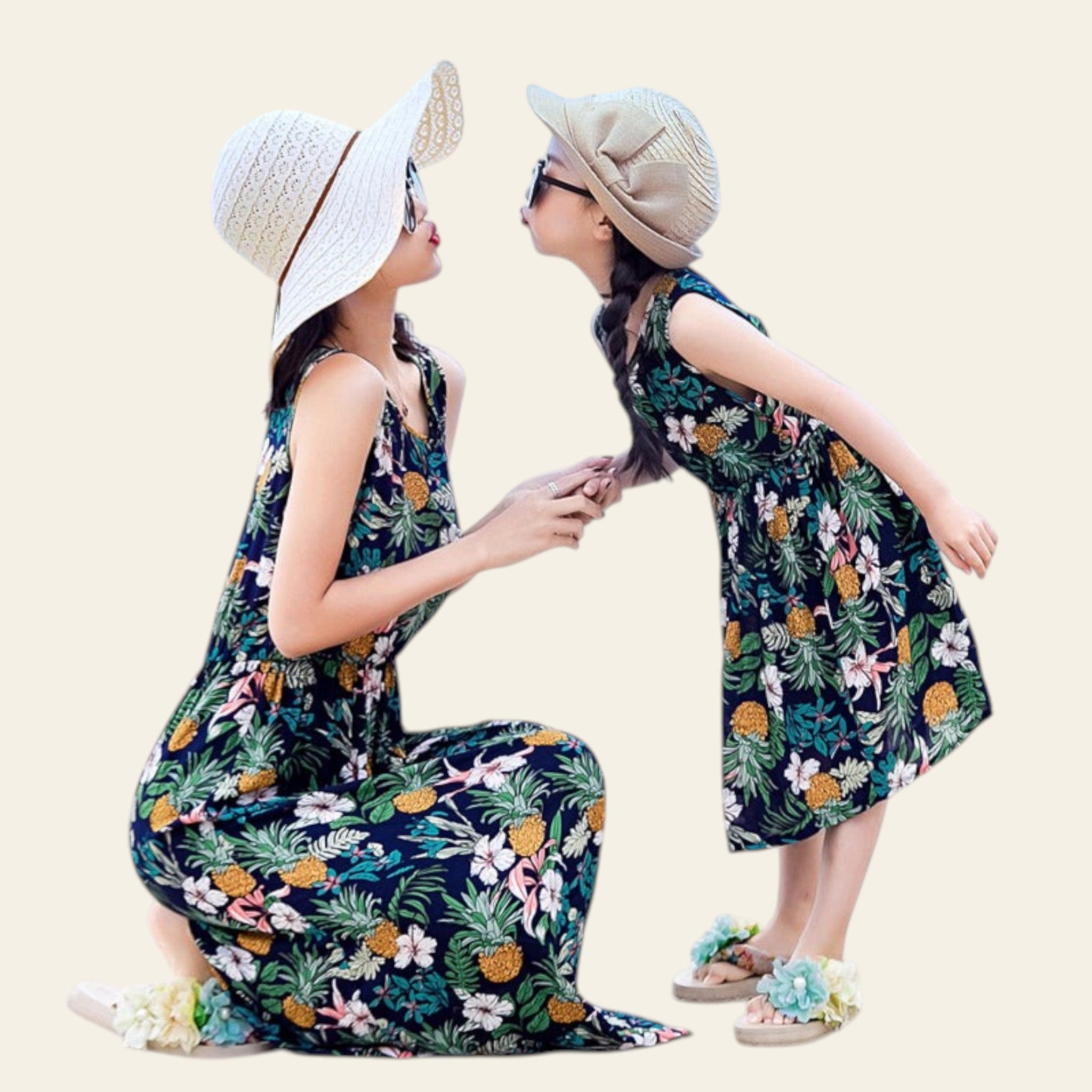 Two women in matching floral dresses on a beach