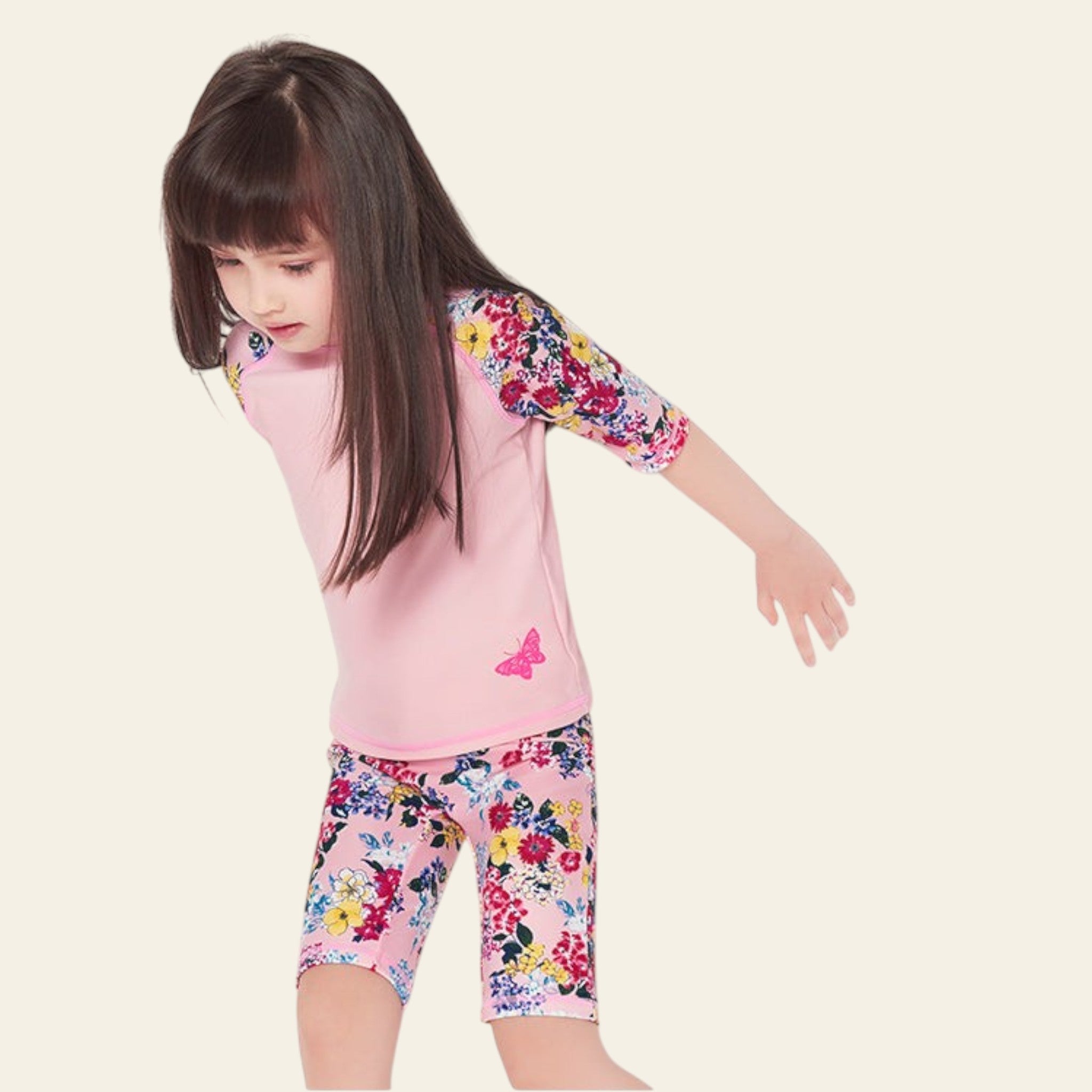 Child wearing a pink floral outfit on a white background