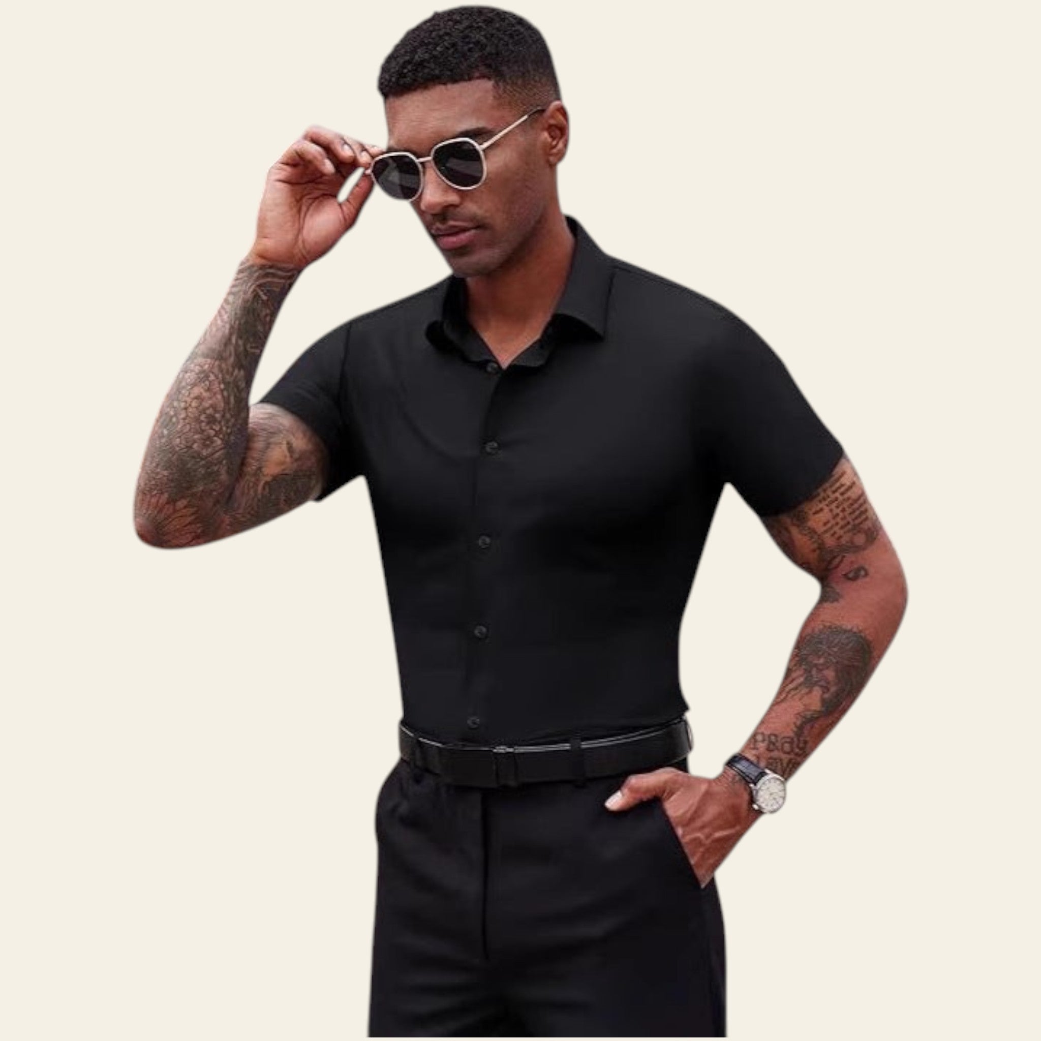 Man in a black outfit posing with sunglasses outdoors