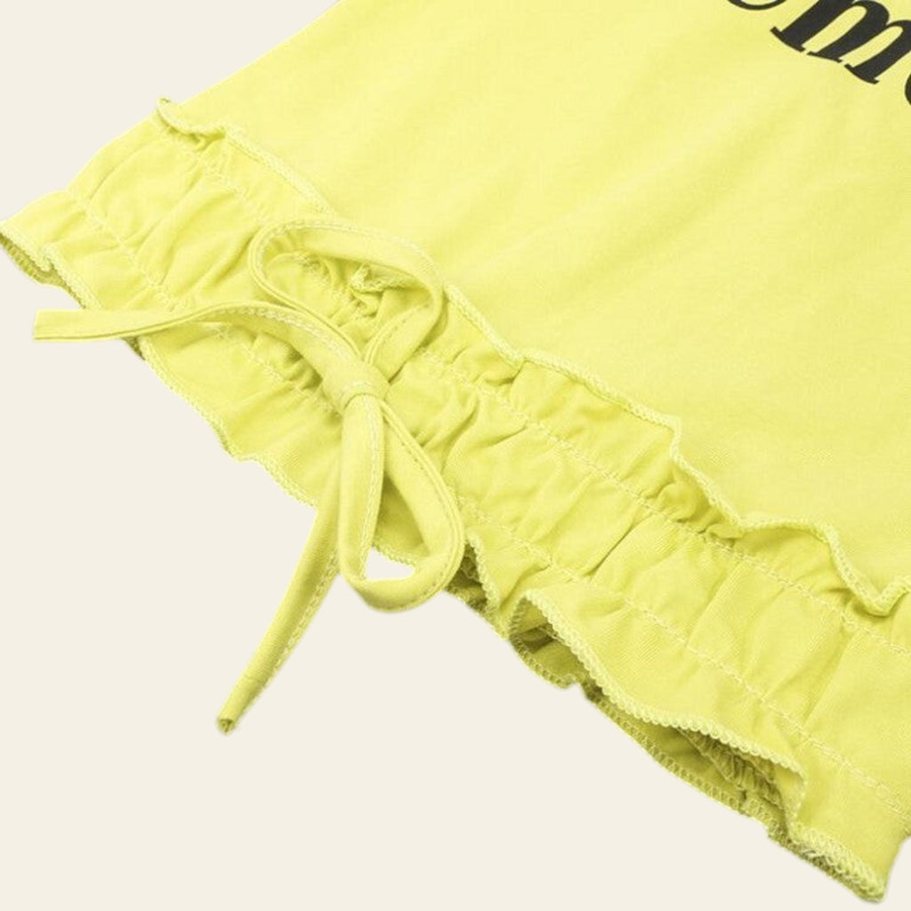 Yellow ruffled shorts with a tie on a gray background
