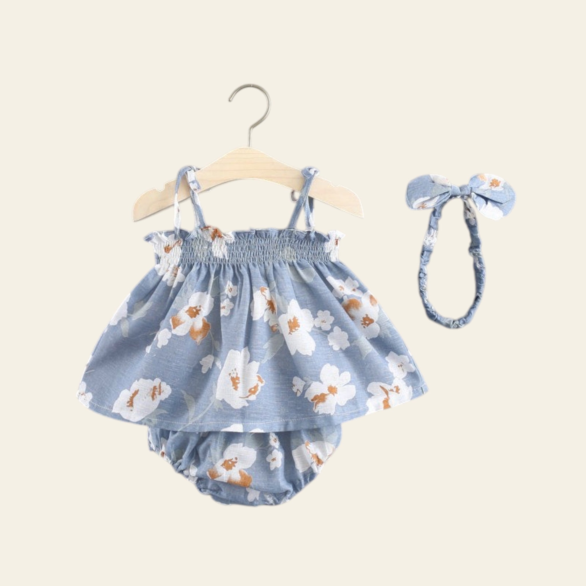 Baby girl's floral outfit with bloomers and headband on a gray background