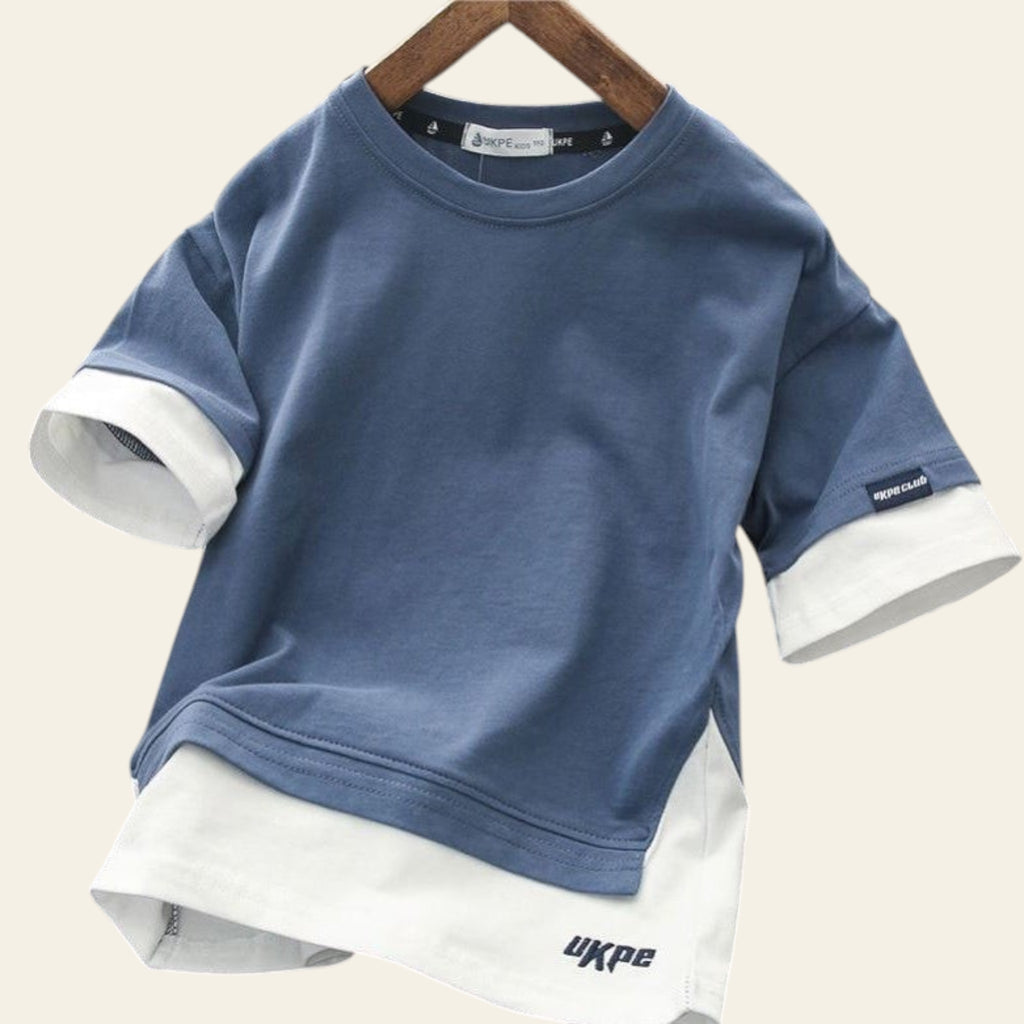 Blue and white layered shirt on a hanger with 'UKPE' branding.