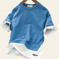 Blue and white layered sweatshirt on a hanger with a blurred background