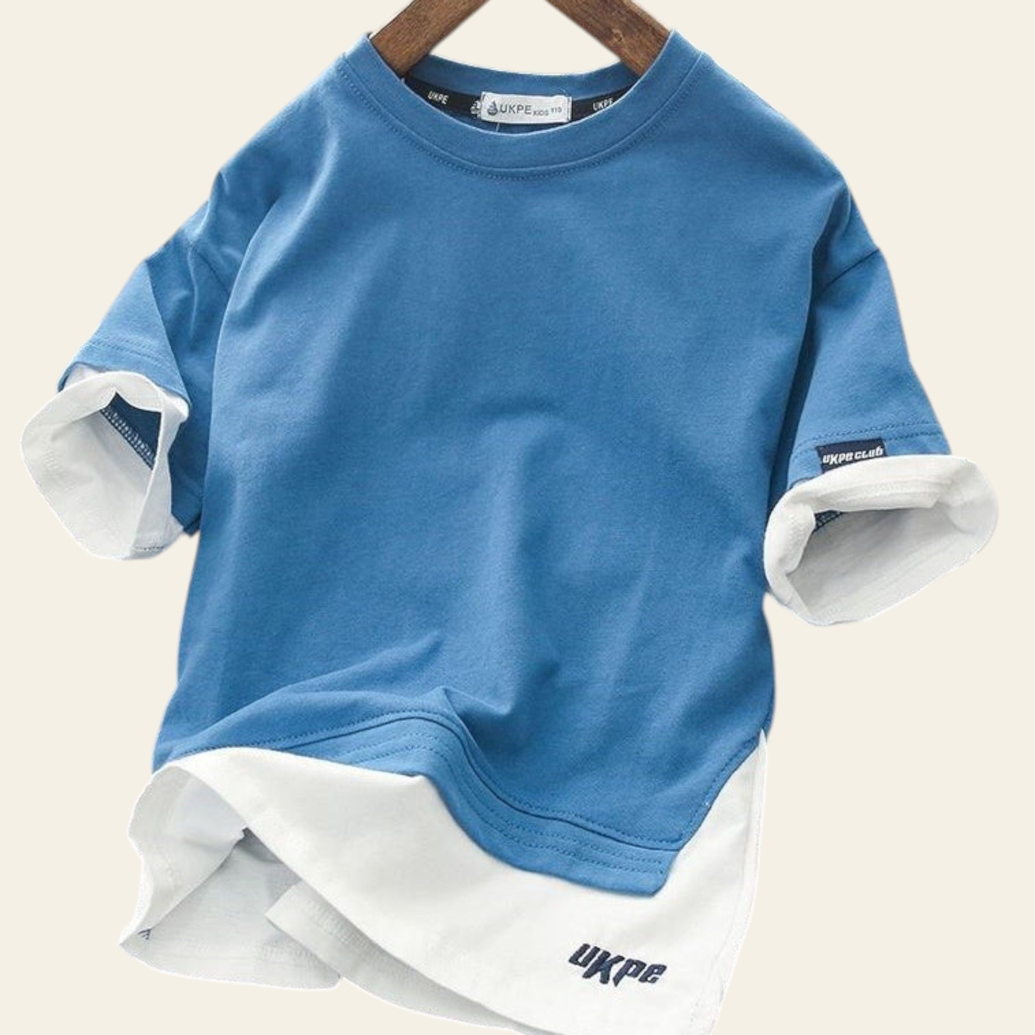 Blue and white layered sweatshirt on a hanger with a blurred background
