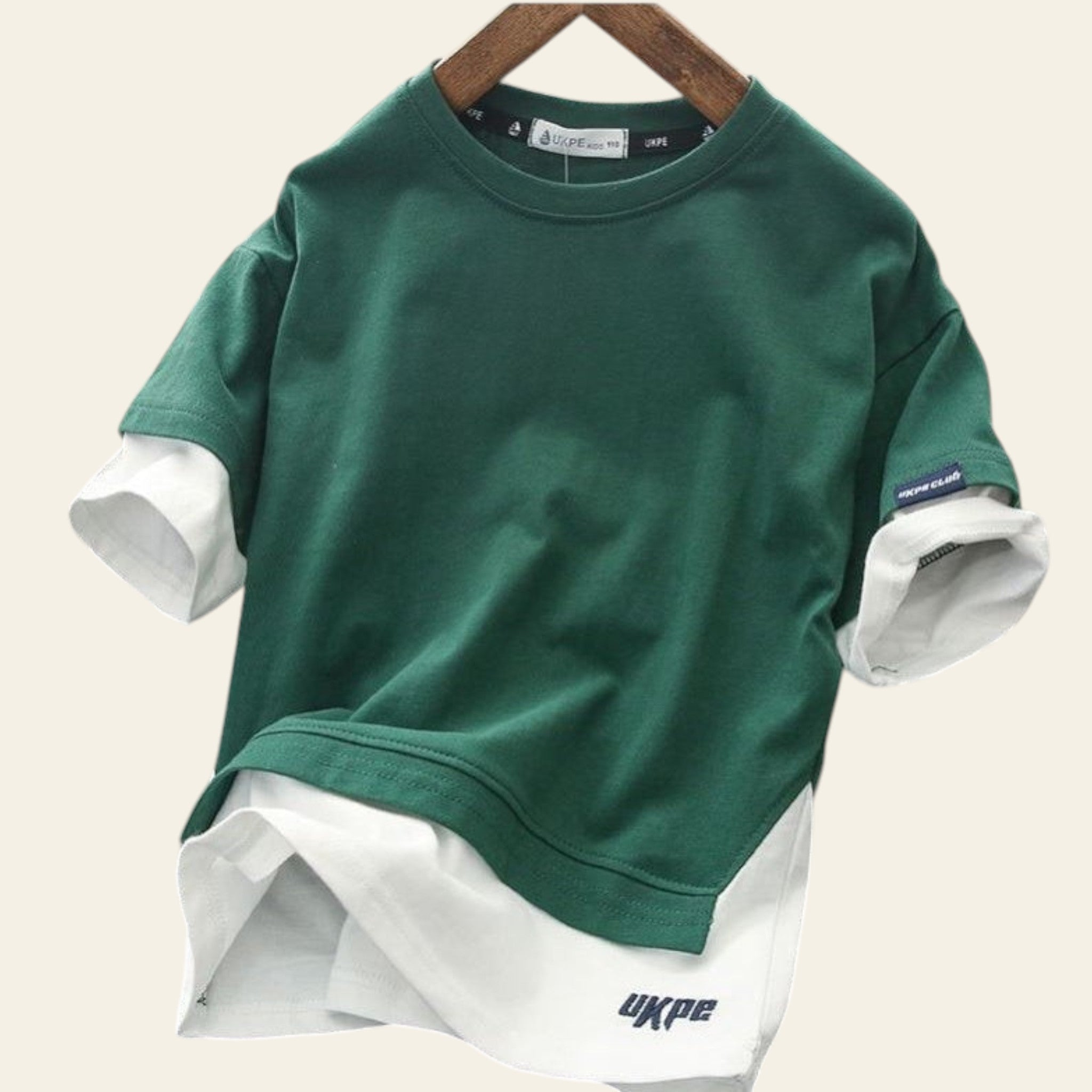 Green and white layered shirt on a hanger with 'UKPE' branding.