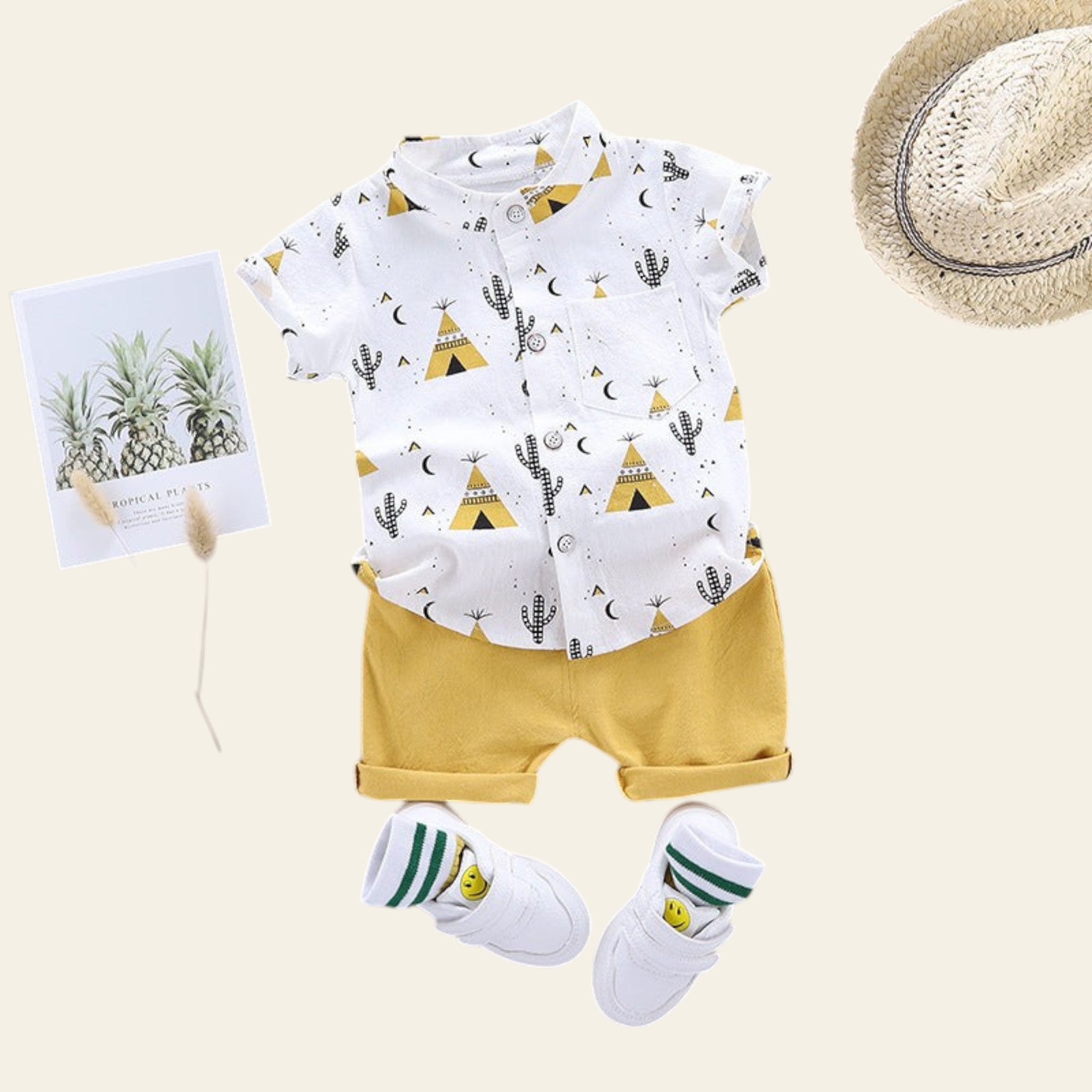 Children's outfit with white shirt and yellow shorts, accompanied by a hat and socks on a gray background.