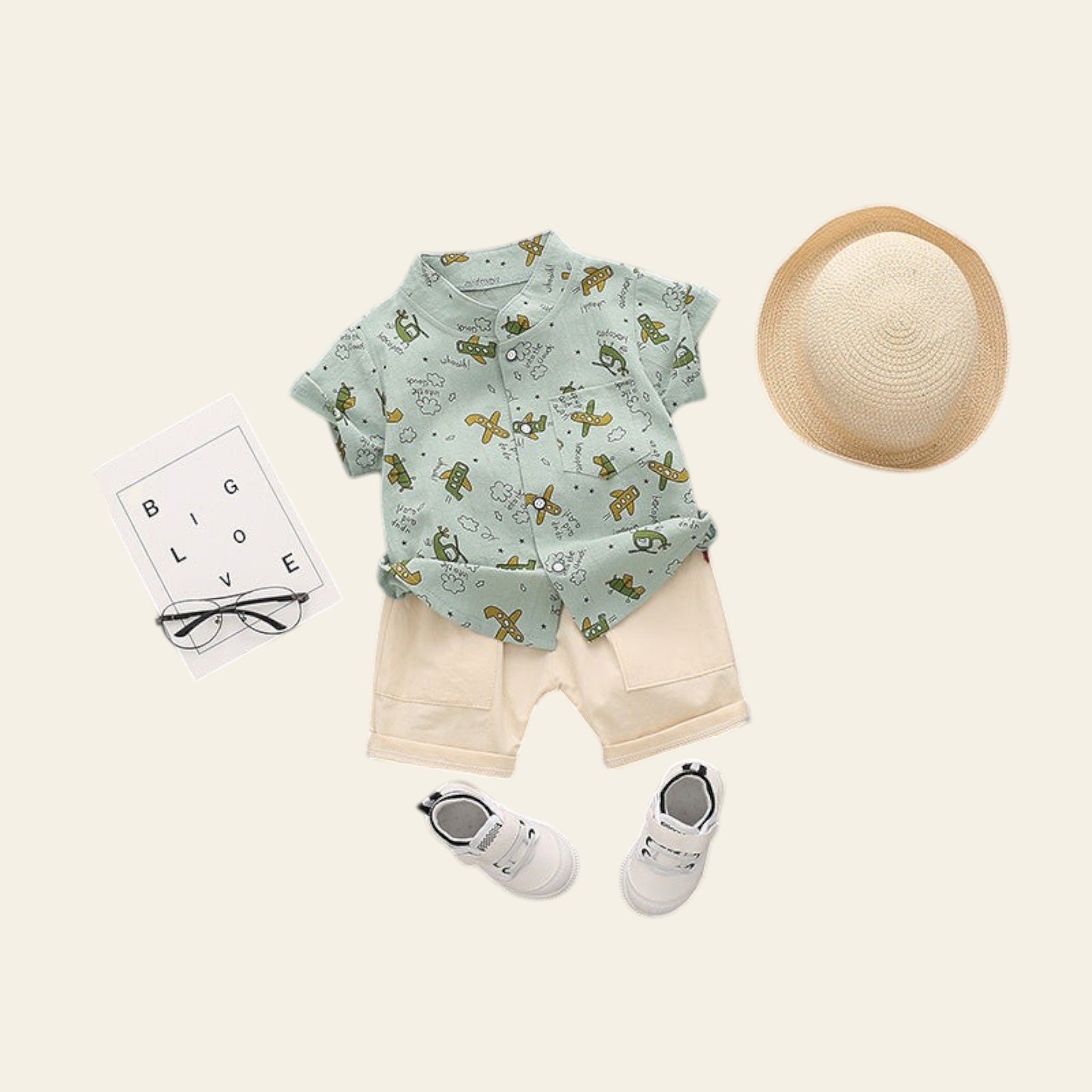 Children's outfit with shirt, shorts, shoes, and hat on a gray background