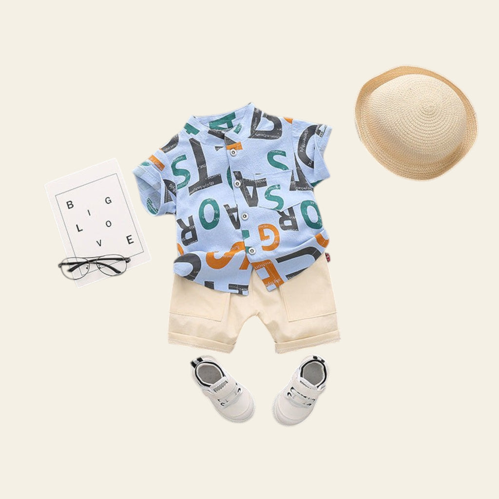 Children's outfit with a shirt, shorts, shoes, and hat on a gray background